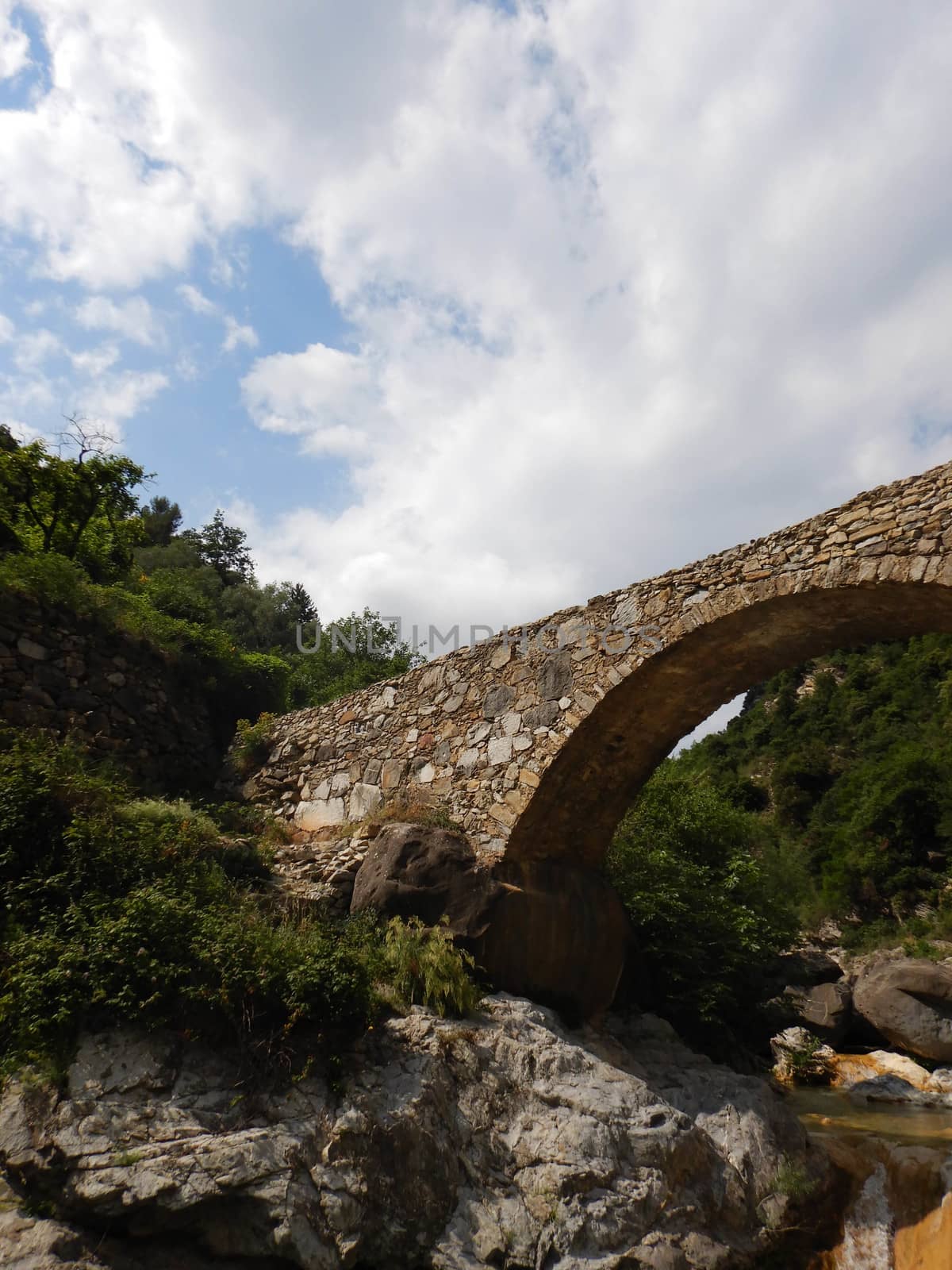 Stone bridge in mountains in the Nervia Valley by cosca