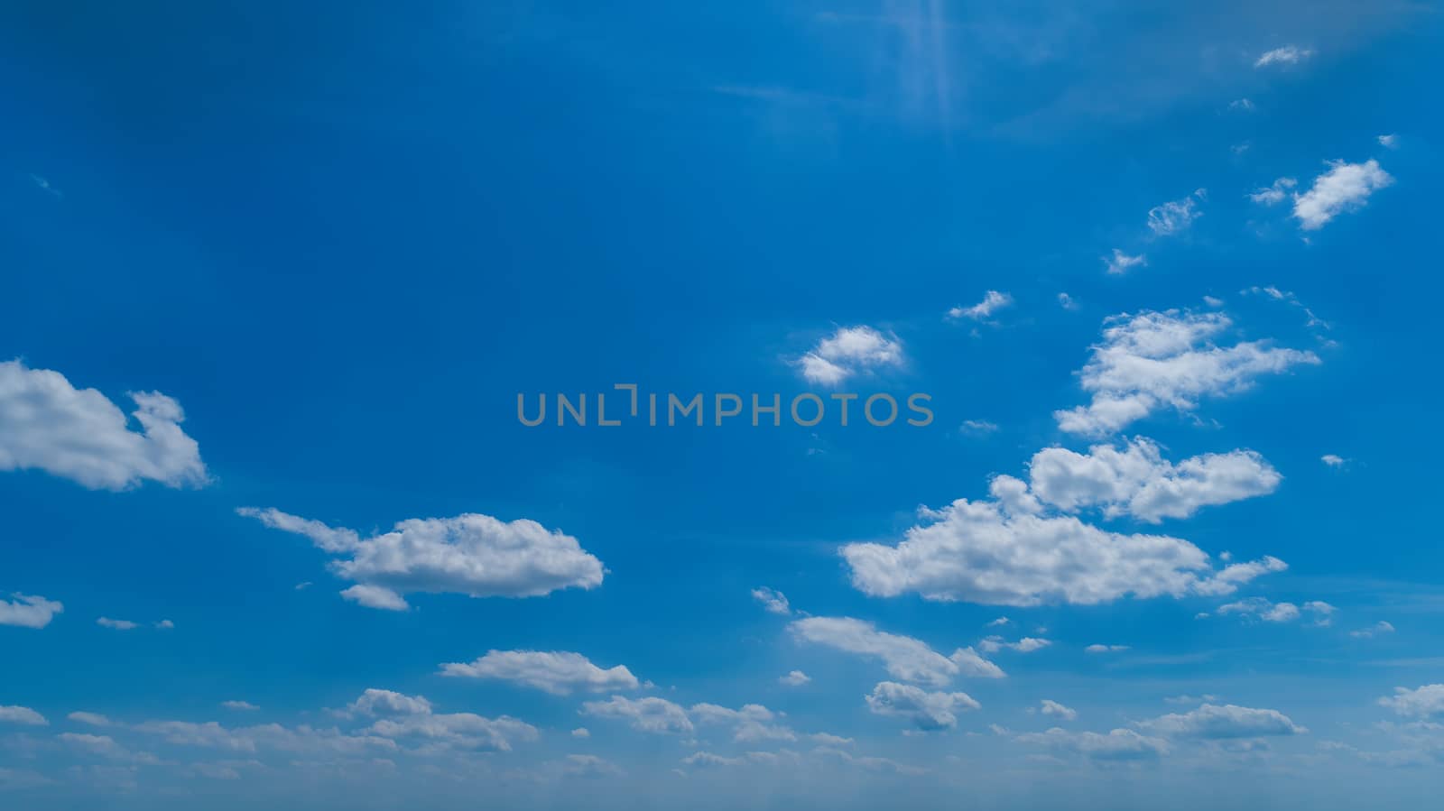 White Fluffy Clouds Floating in the Bright Blue Skies on a Summer Day
