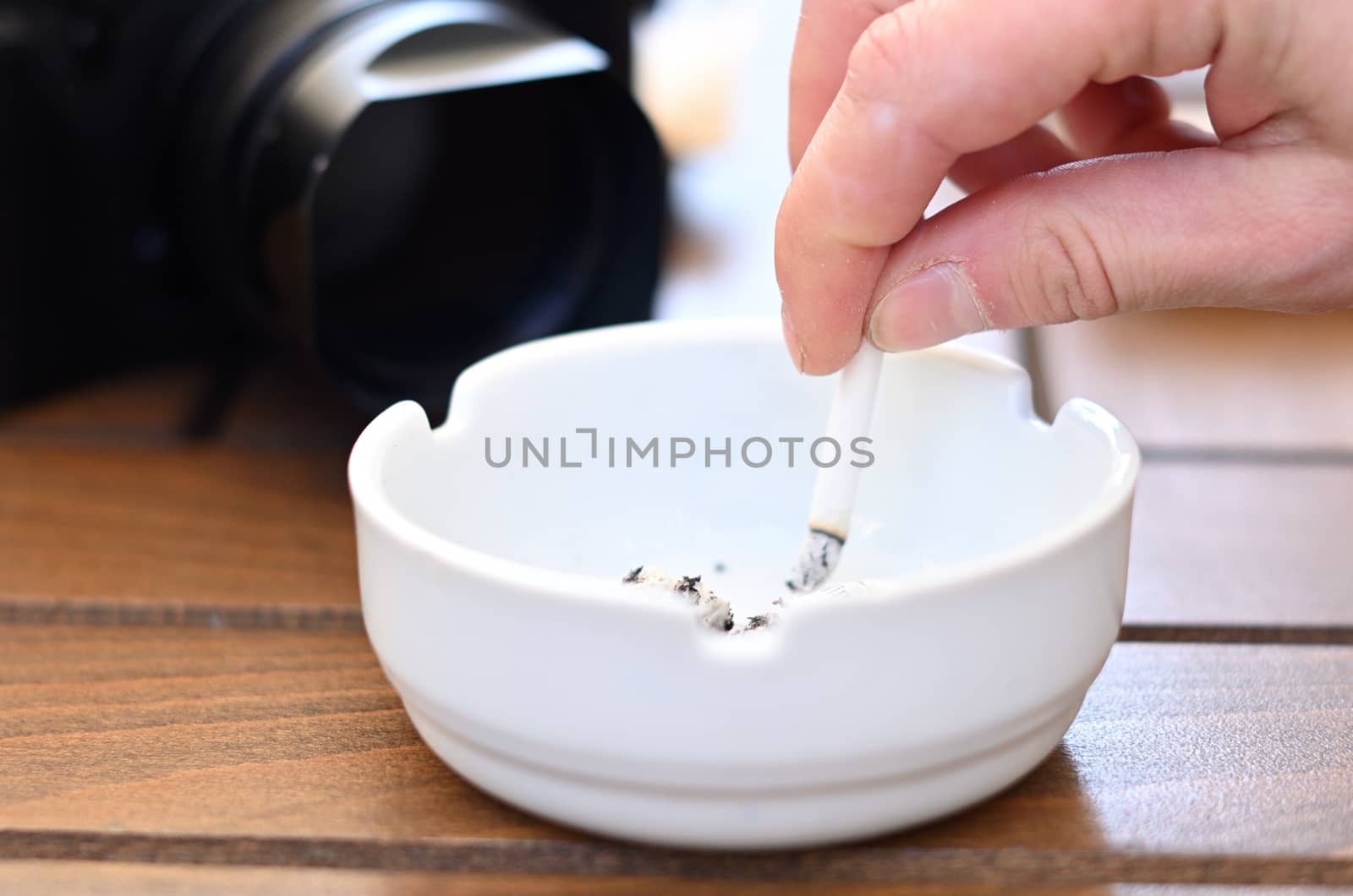 A cigarette that is extinguished in an ashtray by a smoking person. Quit smoking.Stop smoking. Smoking is harmful.