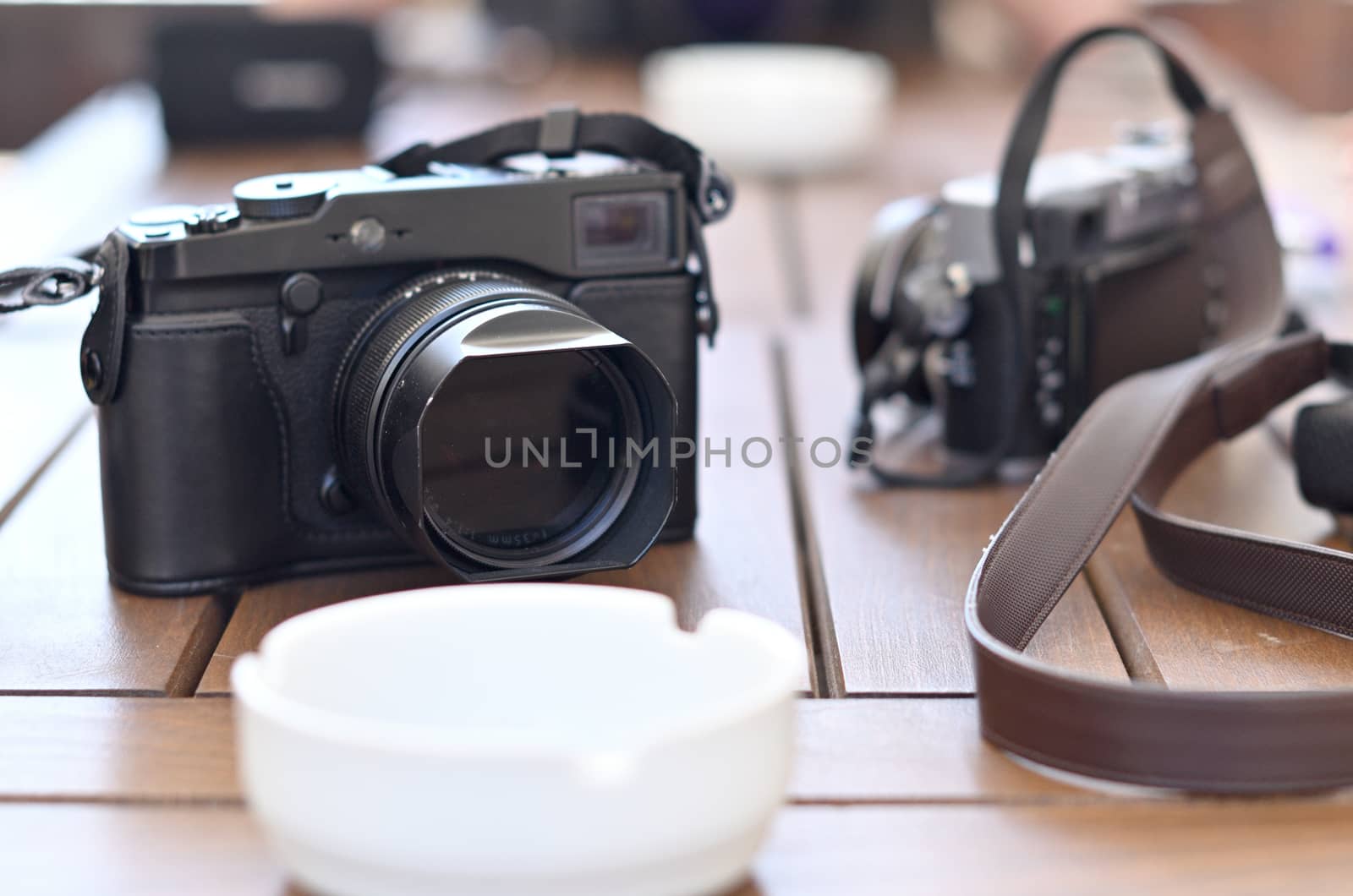 Mirrorless cameras during the break between filming and a white ashtray lying on a wooden table