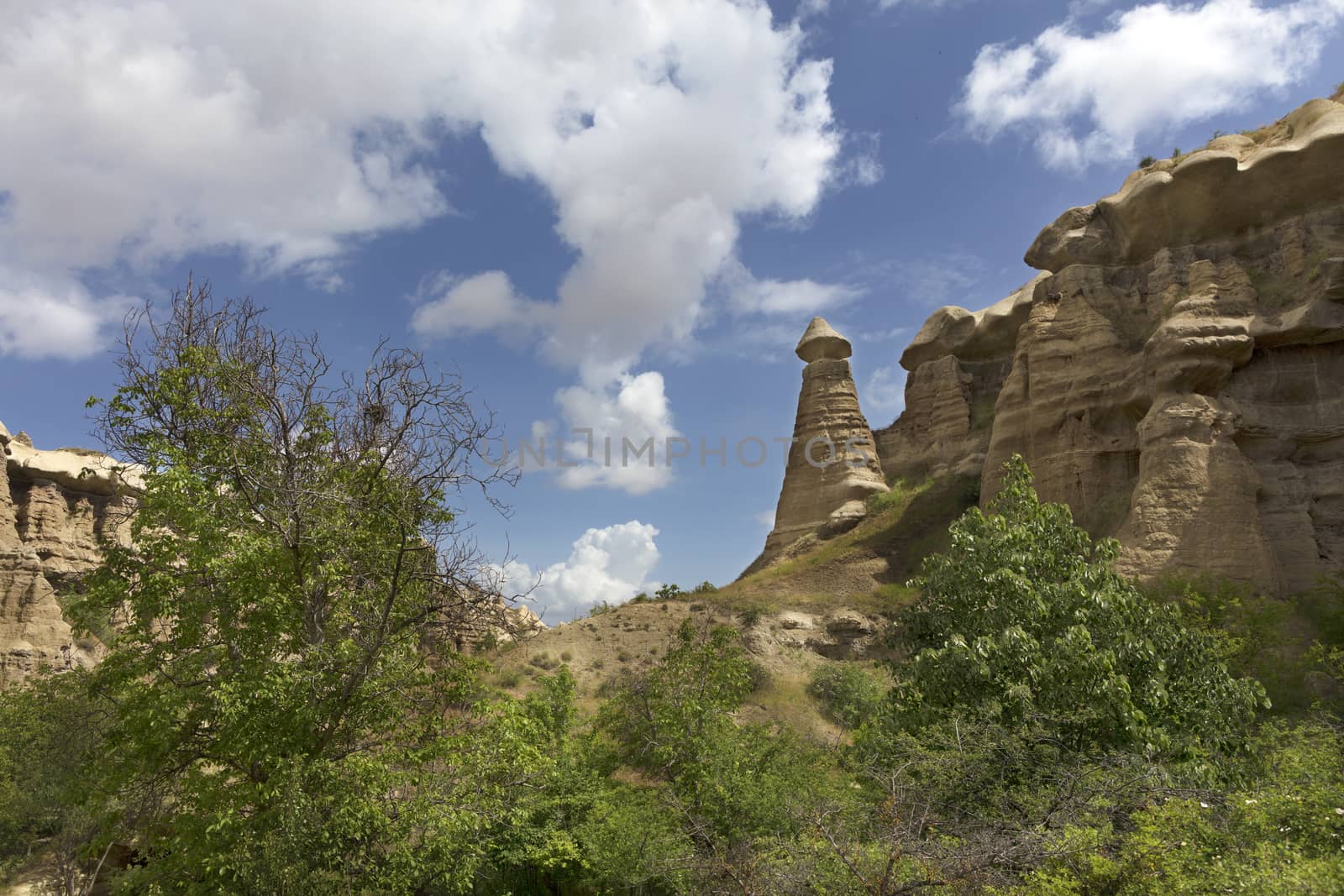 Red and white sandstone cliffs, ancient caves in a mountain landscape between valleys in Cappadocia, central Turkey