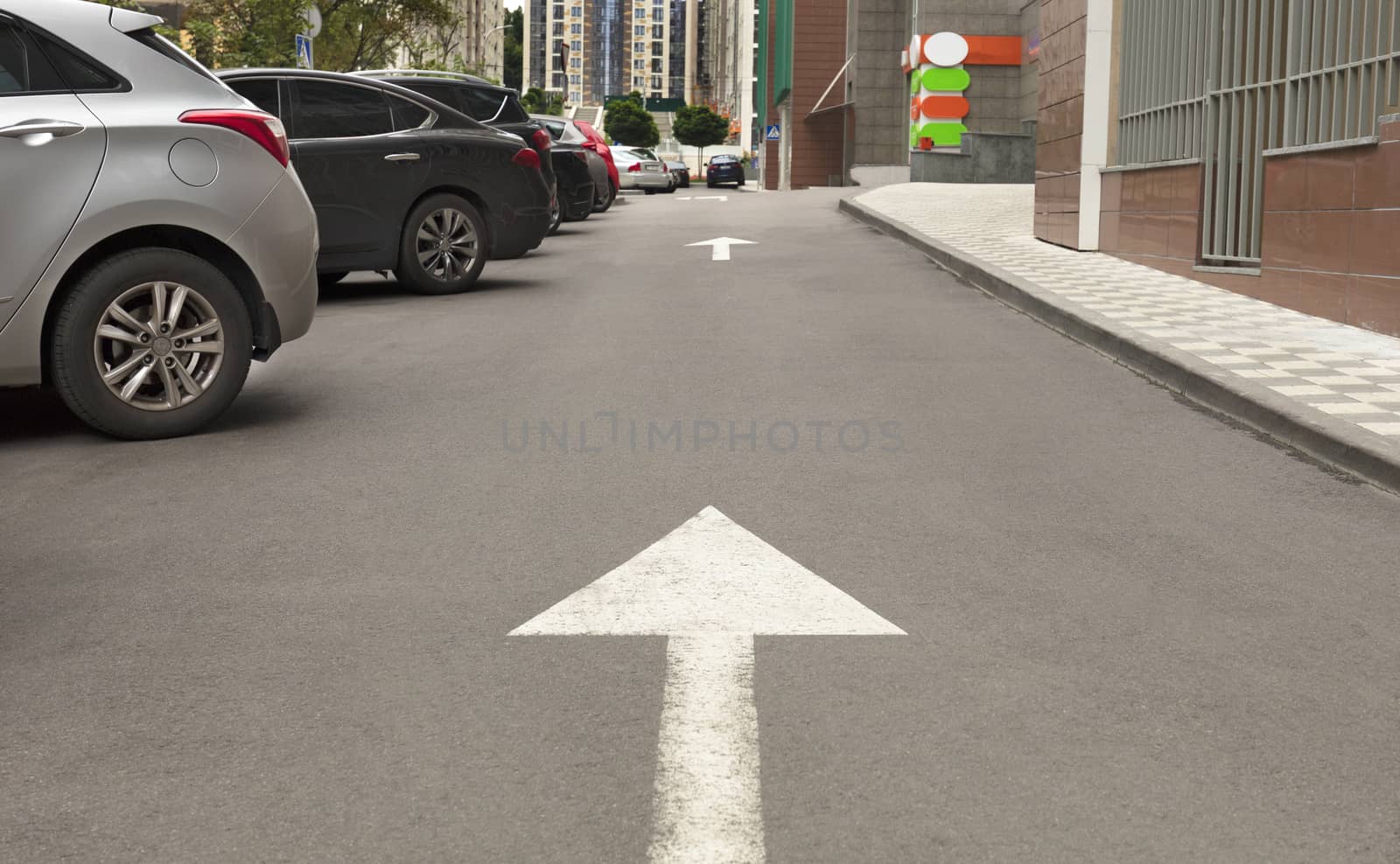 Road marking, arrow on the asphalt indicates the direction for driving vehicles near the local area