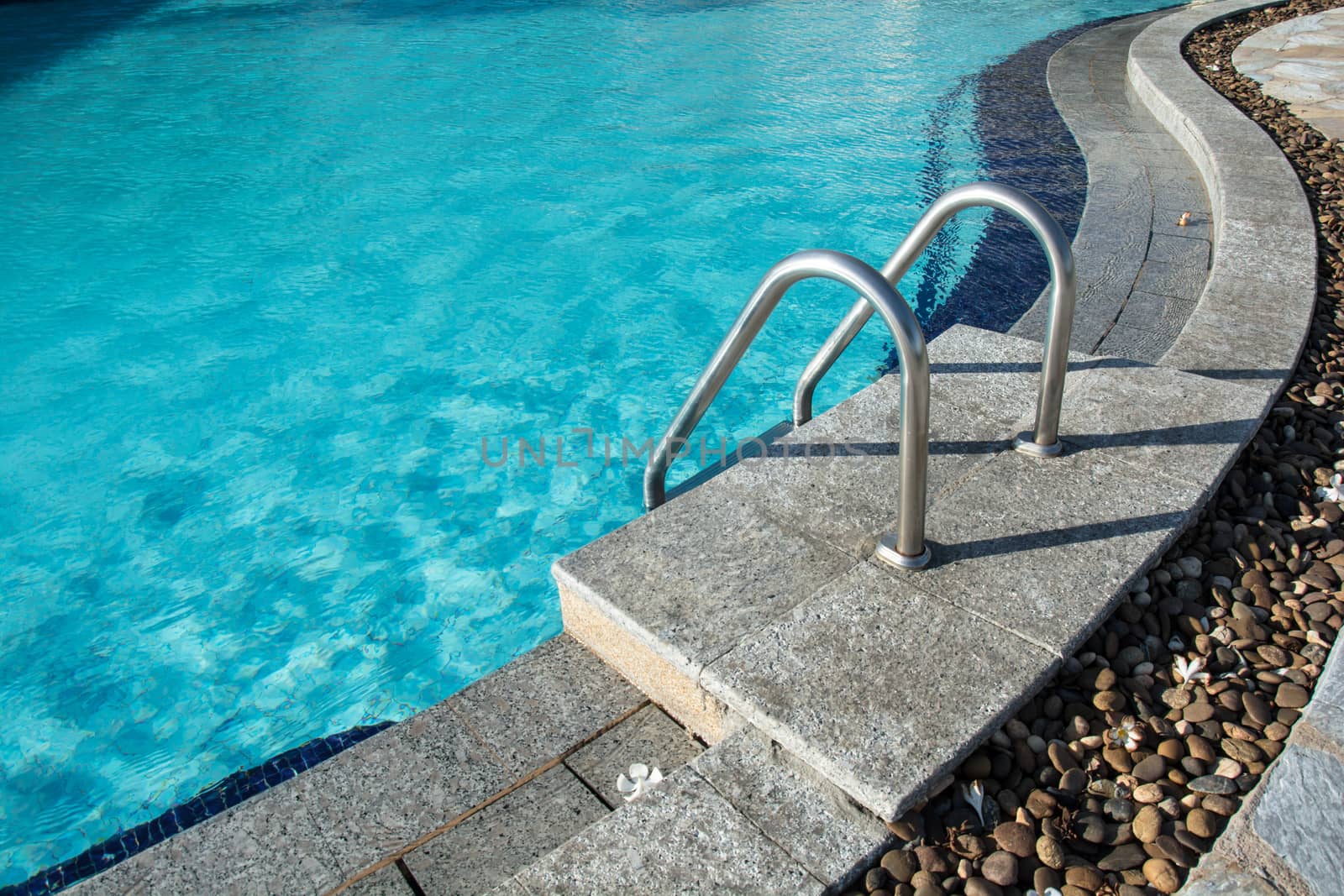 Grab bars ladder in the blue swimming pool
