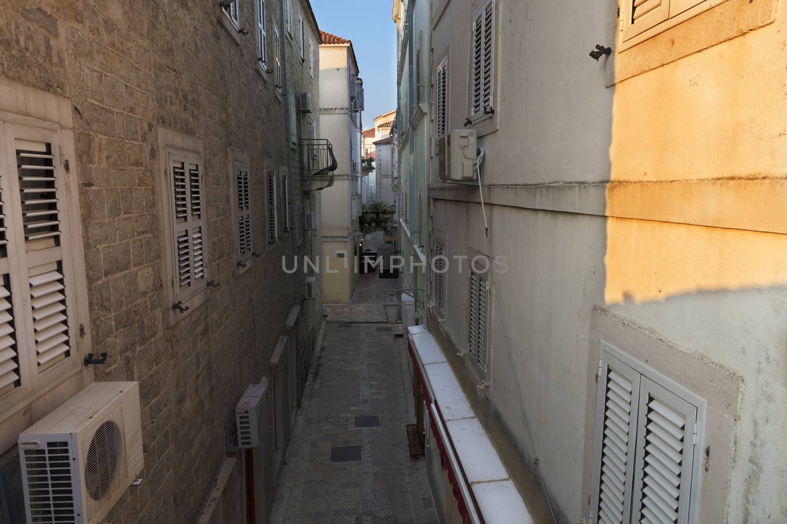 The old town of Budva in Montenegro, early morning, the sun creeps on a narrow street.