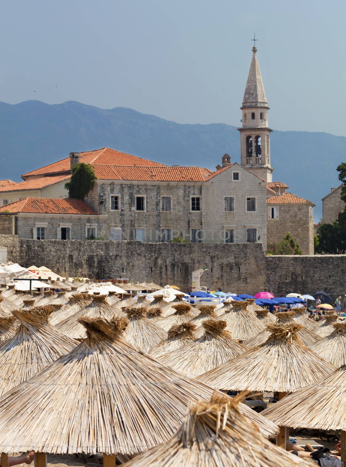 Thatched roofs of beach umbrellas in the bright sun by Sergii