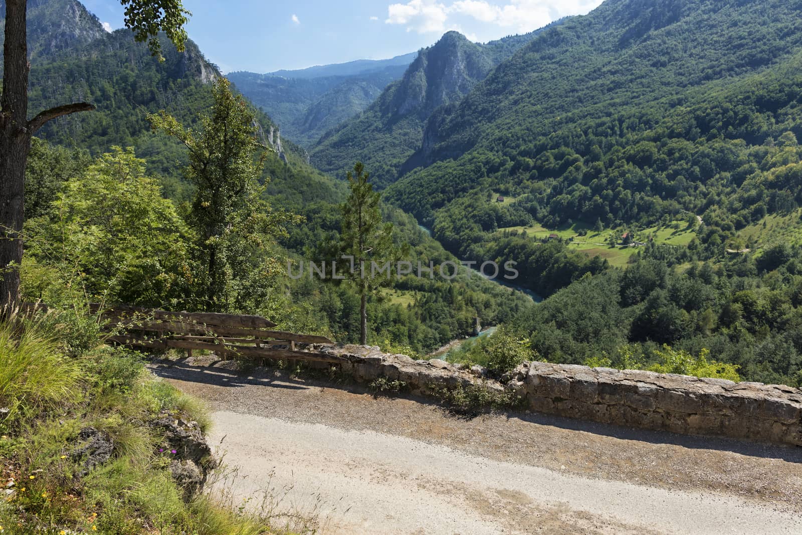 A stone road passes among the mountains, above a clean mountain turquoise river in the national park of central Montenegro. Ecological concept.