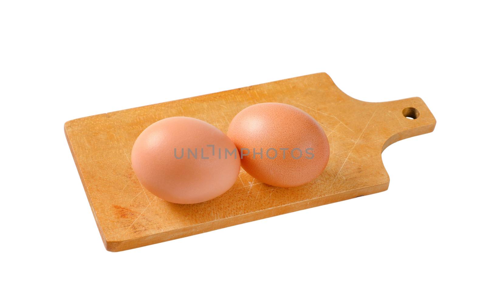Two brown eggs on cutting board by Digifoodstock