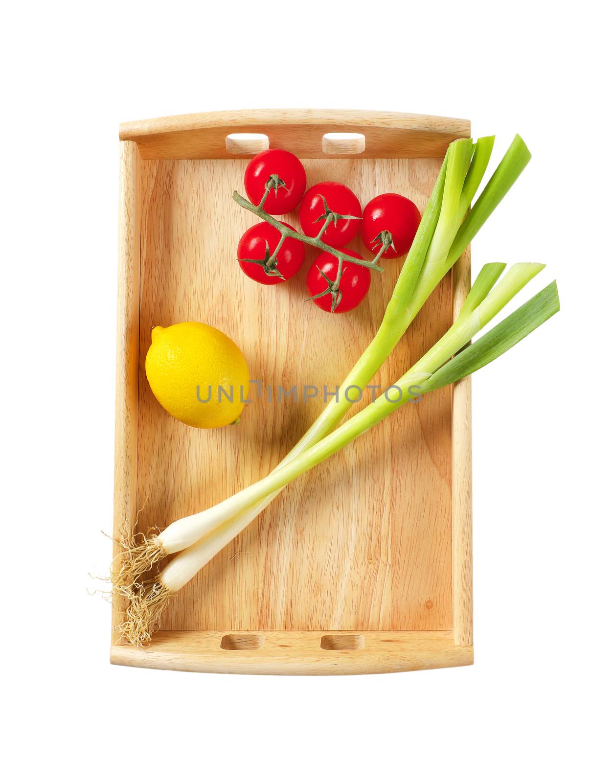 Spring onion, tomatoes and lemon on wooden serving tray isolated on white