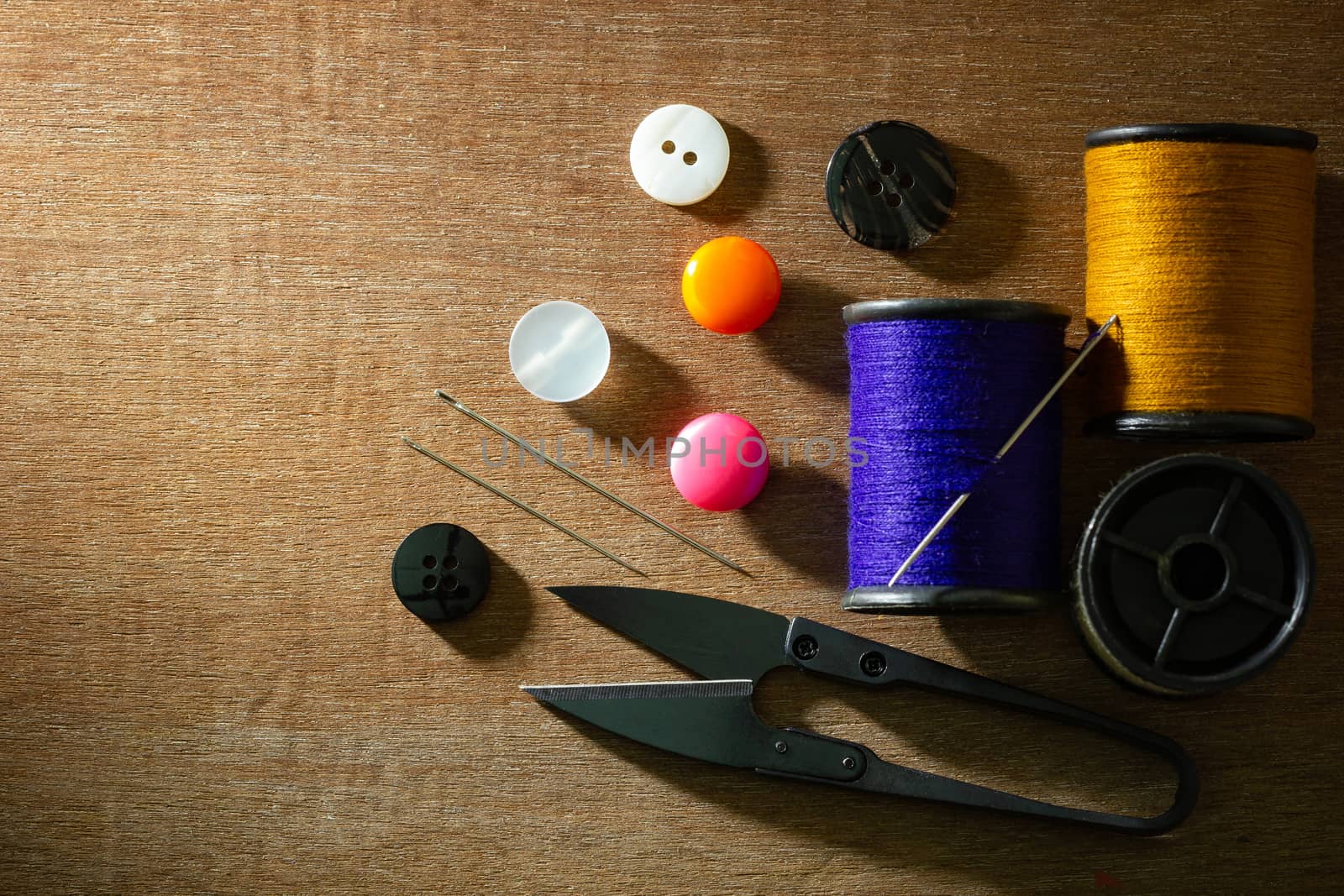 Needle and threads against plastic button. by SaitanSainam
