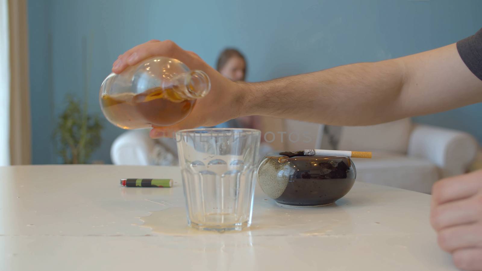 Hand of a man pouring whiskey into a glass by Alize