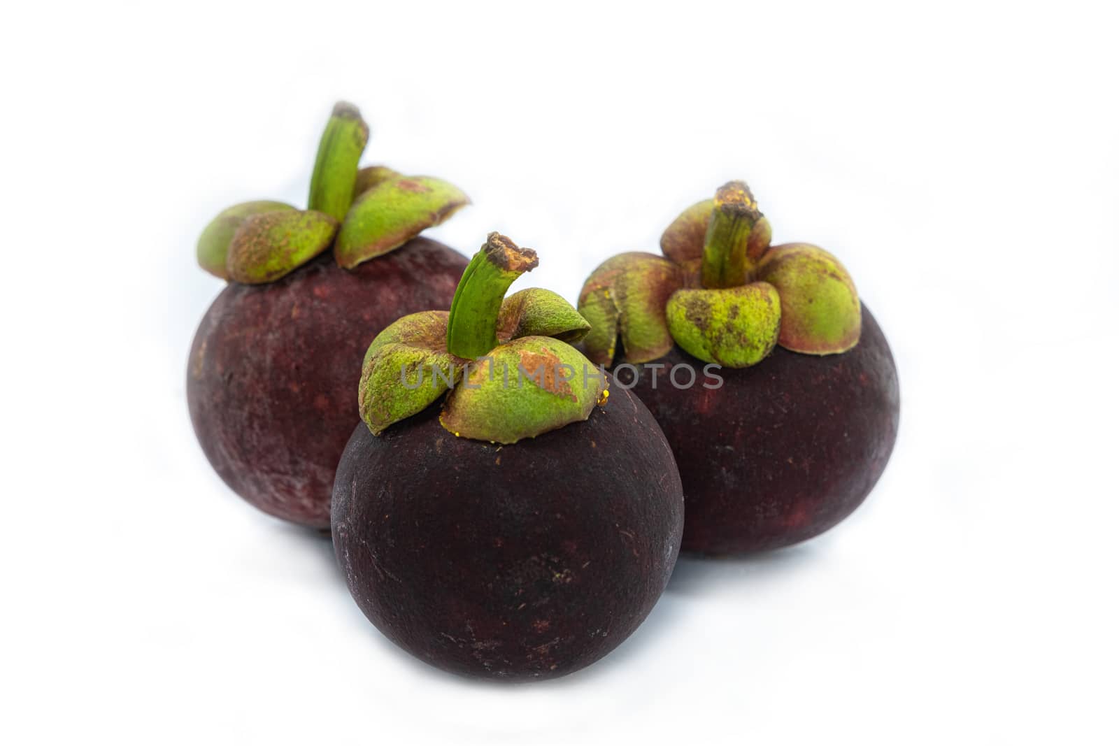 Mangosteen (Garcinia mangostana) is an exotic, tropical fruit with a slightly sweet and sour flavor, isolated on white background. by peerapixs