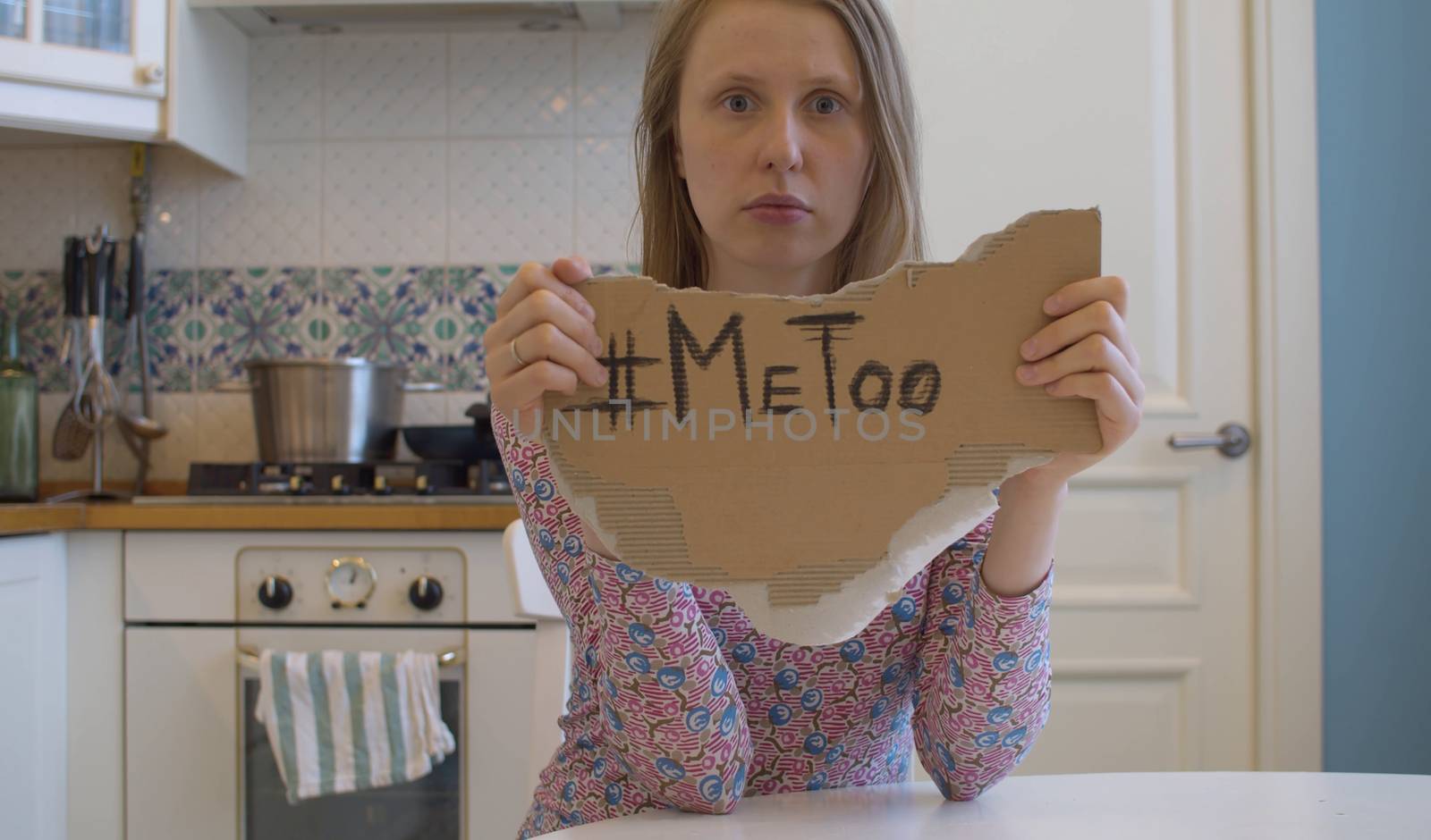 Woman with sad unhappy face holding a piece of cardboard with hashtag me too. Movement against sexual harassment.