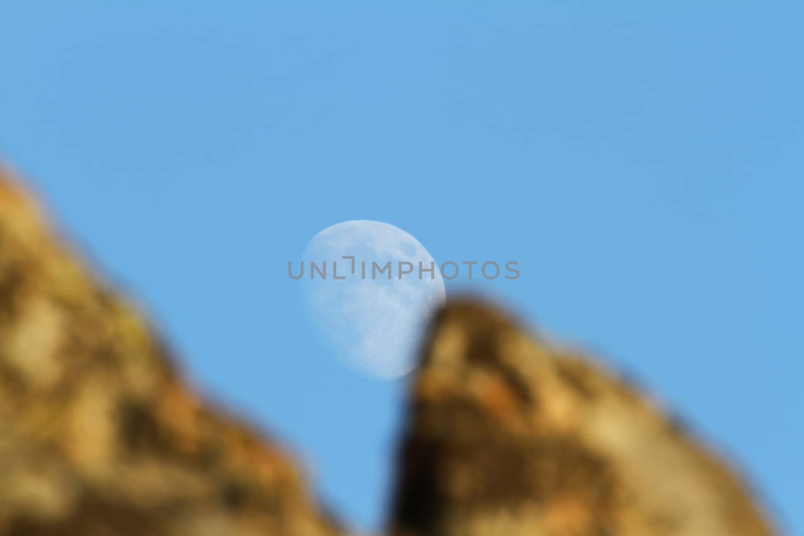 moon between two rocks day