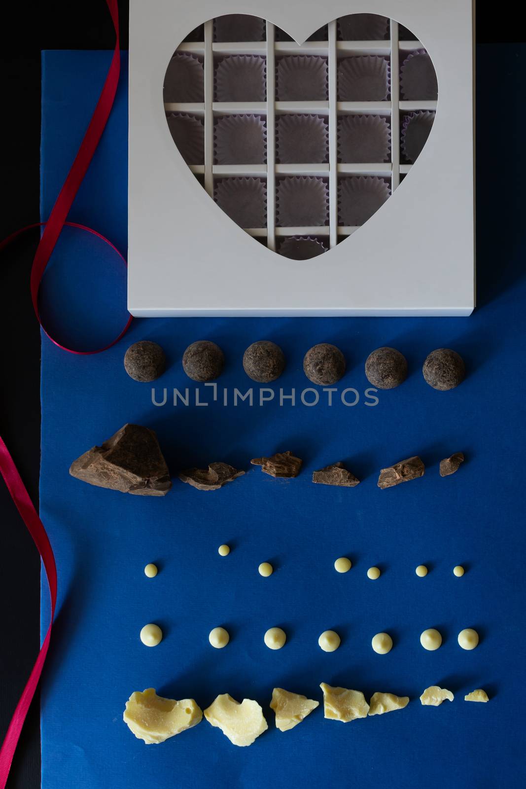 Pieces of chocolate on a blue background. Ingredients for making healthy and delicious sugar-free sweets at home. Home made chocolate for valentine day gift or other holidays