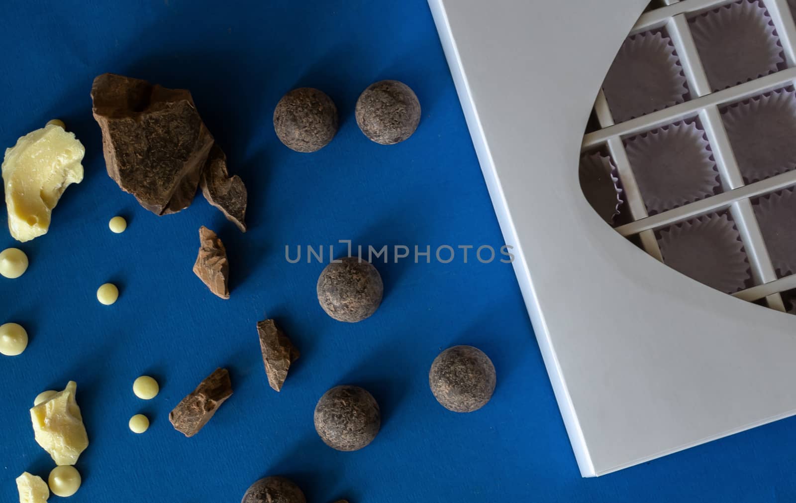 Pieces of chocolate on a blue background. Ingredients for making healthy and delicious sugar-free sweets at home. Home made chocolate for valentine day gift or other holidays