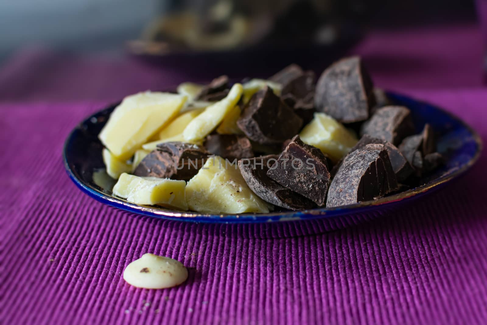 Broken pieces of dark bitter chocolate and white milk chocolate. Ingredients for home cooking of healthy sweets without sugar.