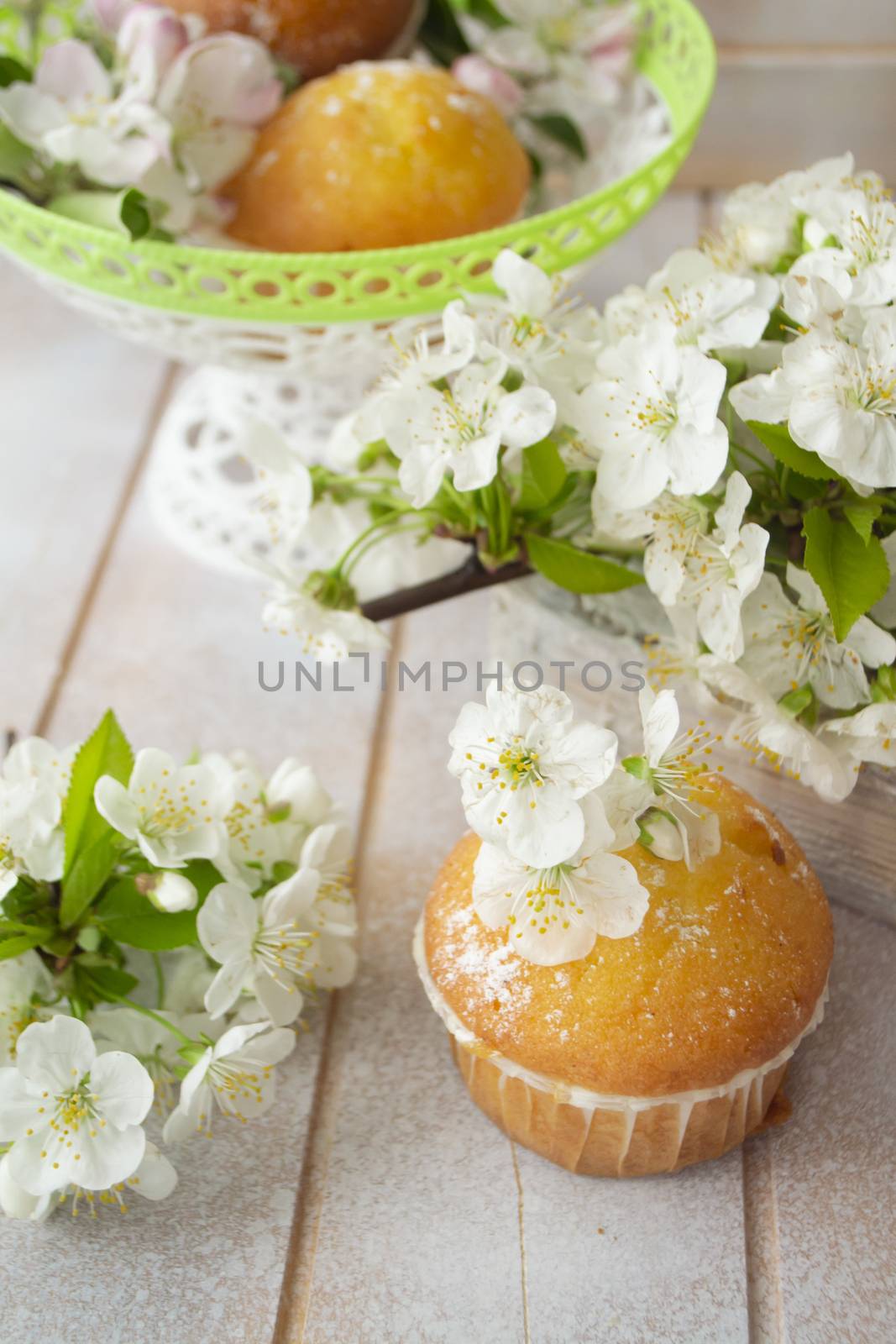Golden muffin cupcakes, vertical image, spring flowers on shabby background