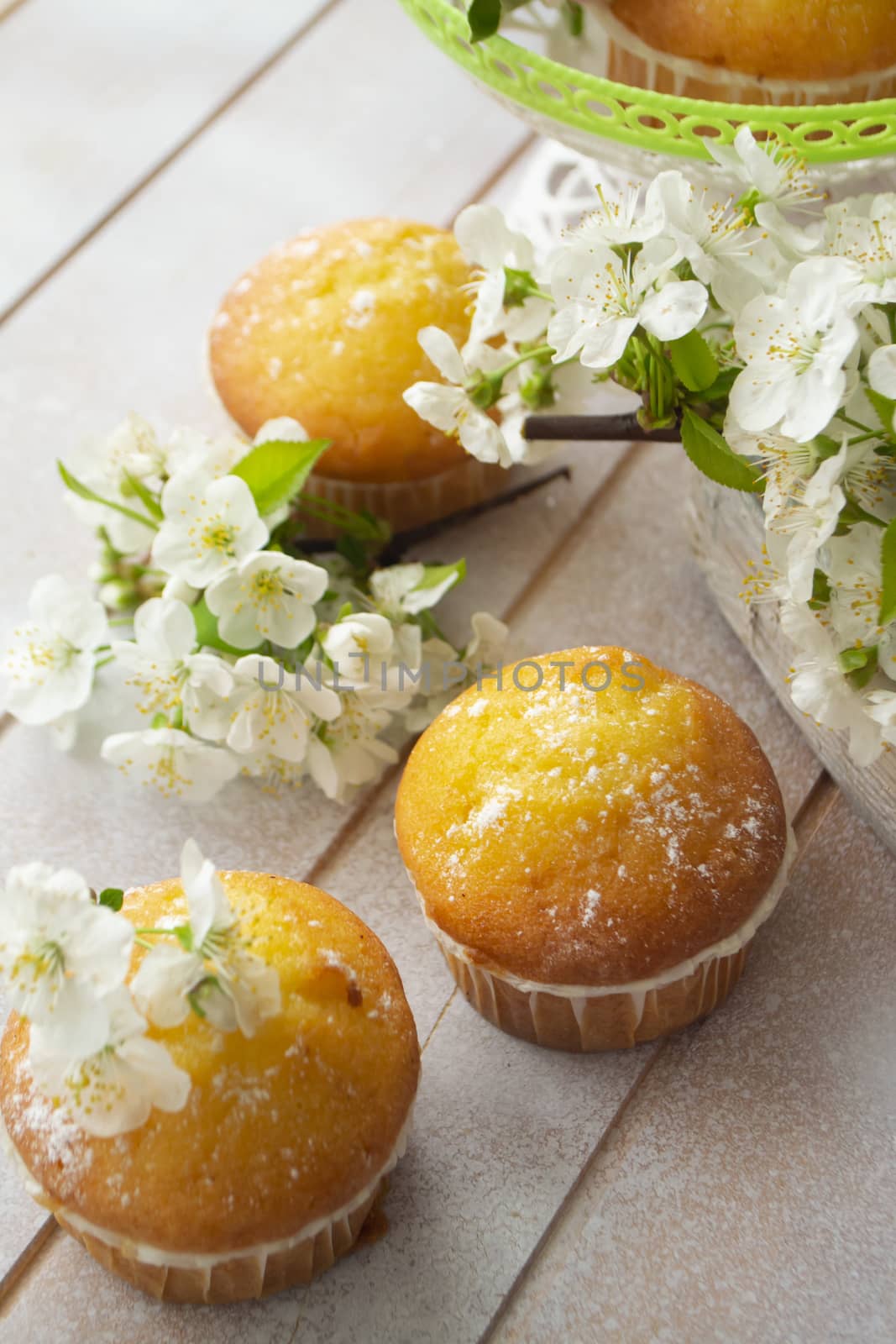 Golden muffins with cherriy flowers on shabby background