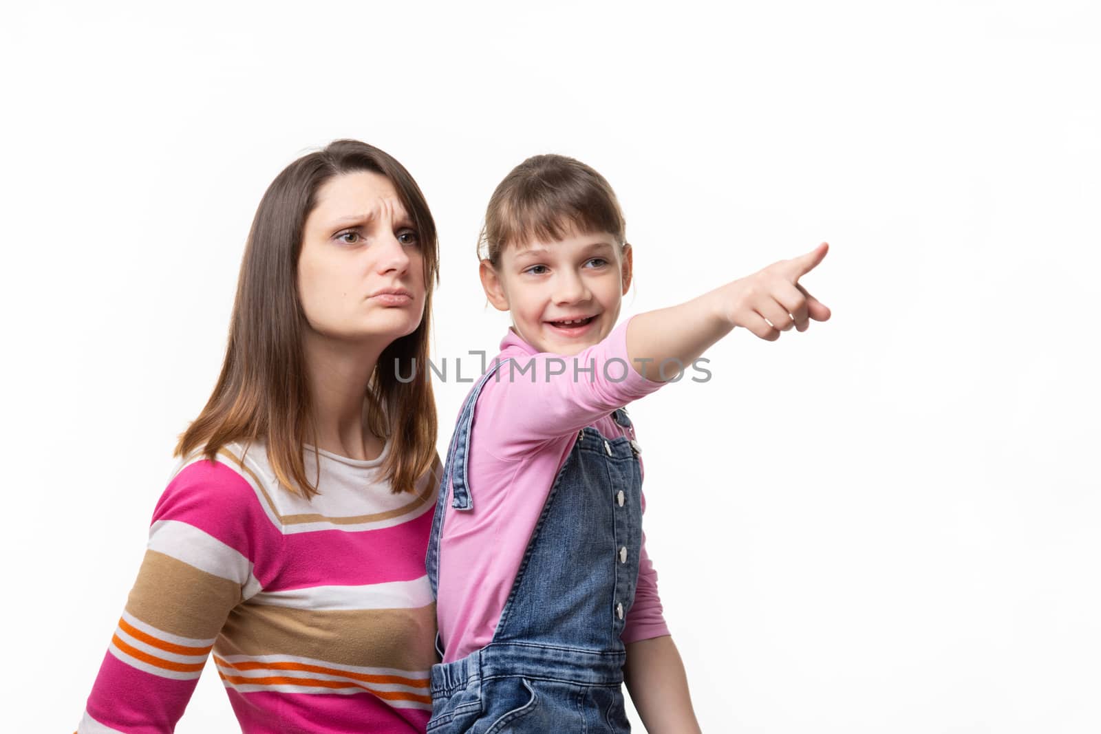 Happy girl shows something to mom with finger, isolated on white background