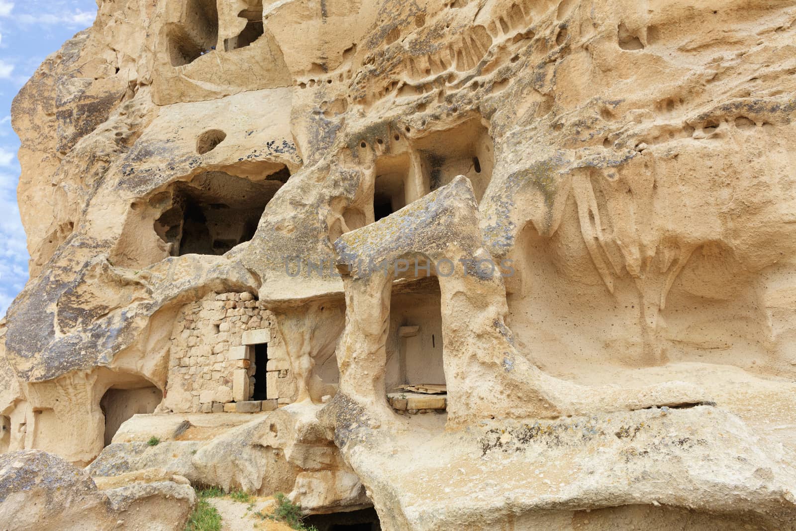 Many corridors and rooms are hollowed out in an old antique rock in the valley of Cappadocia, close-up view.