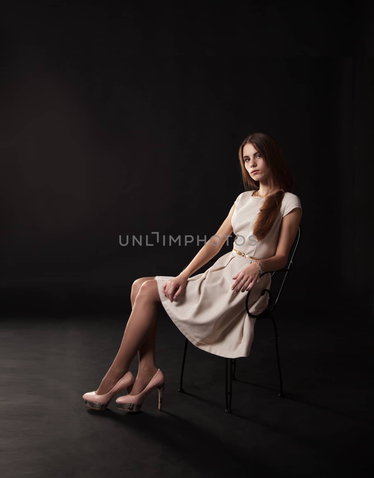 young beautiful girl in a bright dress sitting on the chair by raddnatt