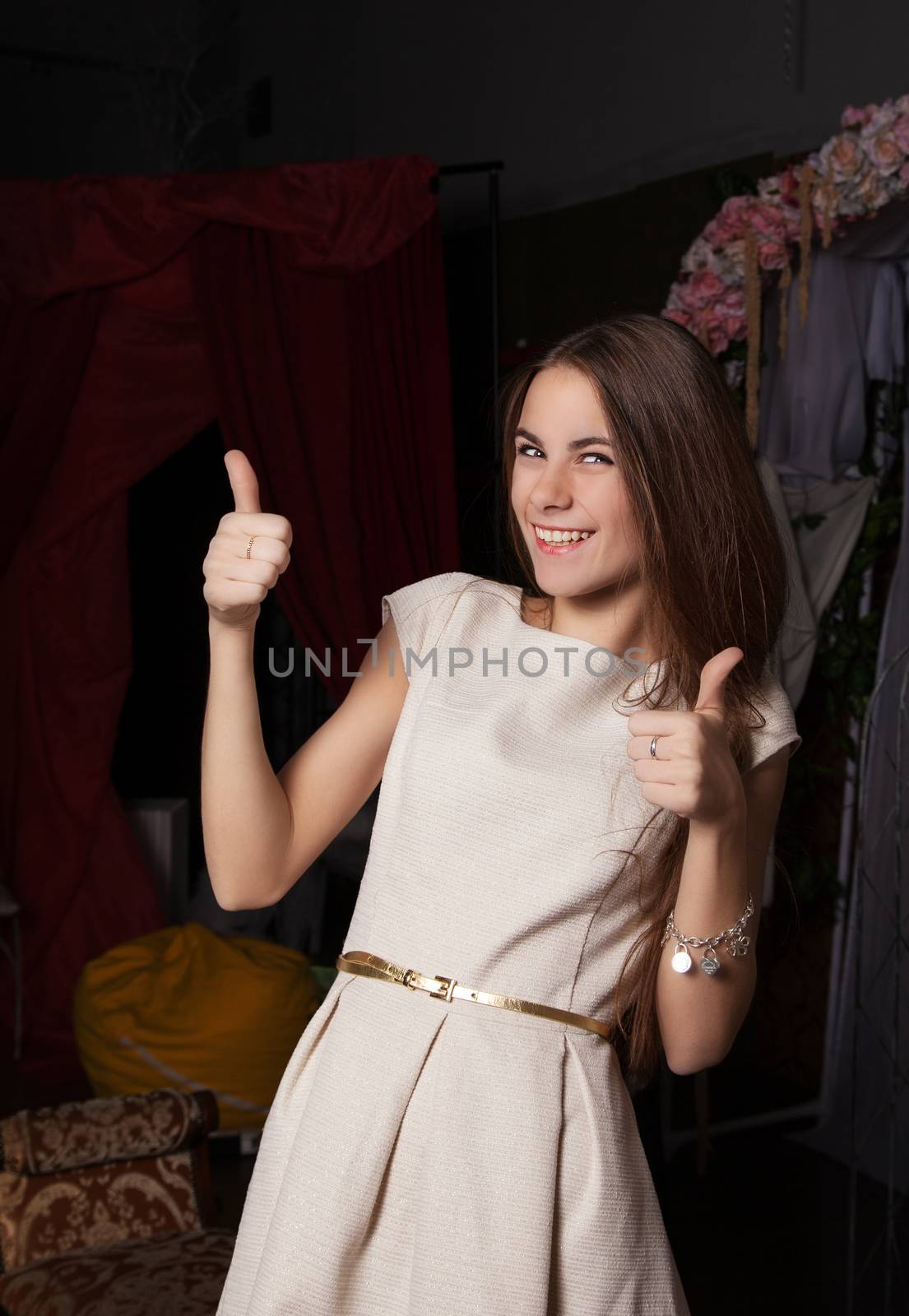 joyful girl in light dress shows gesture all right