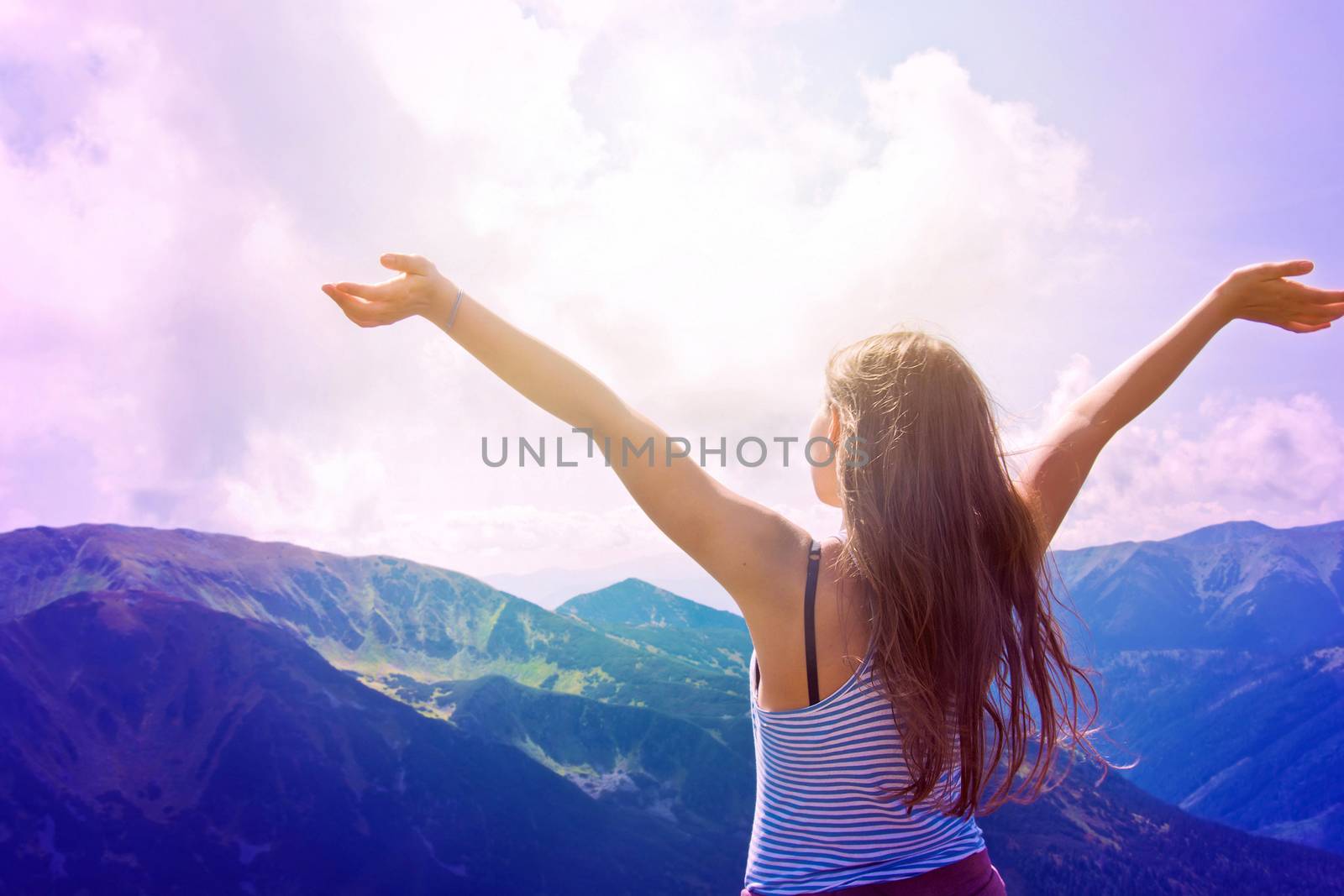 Teenage girl feel freedom in mountains scenery. 