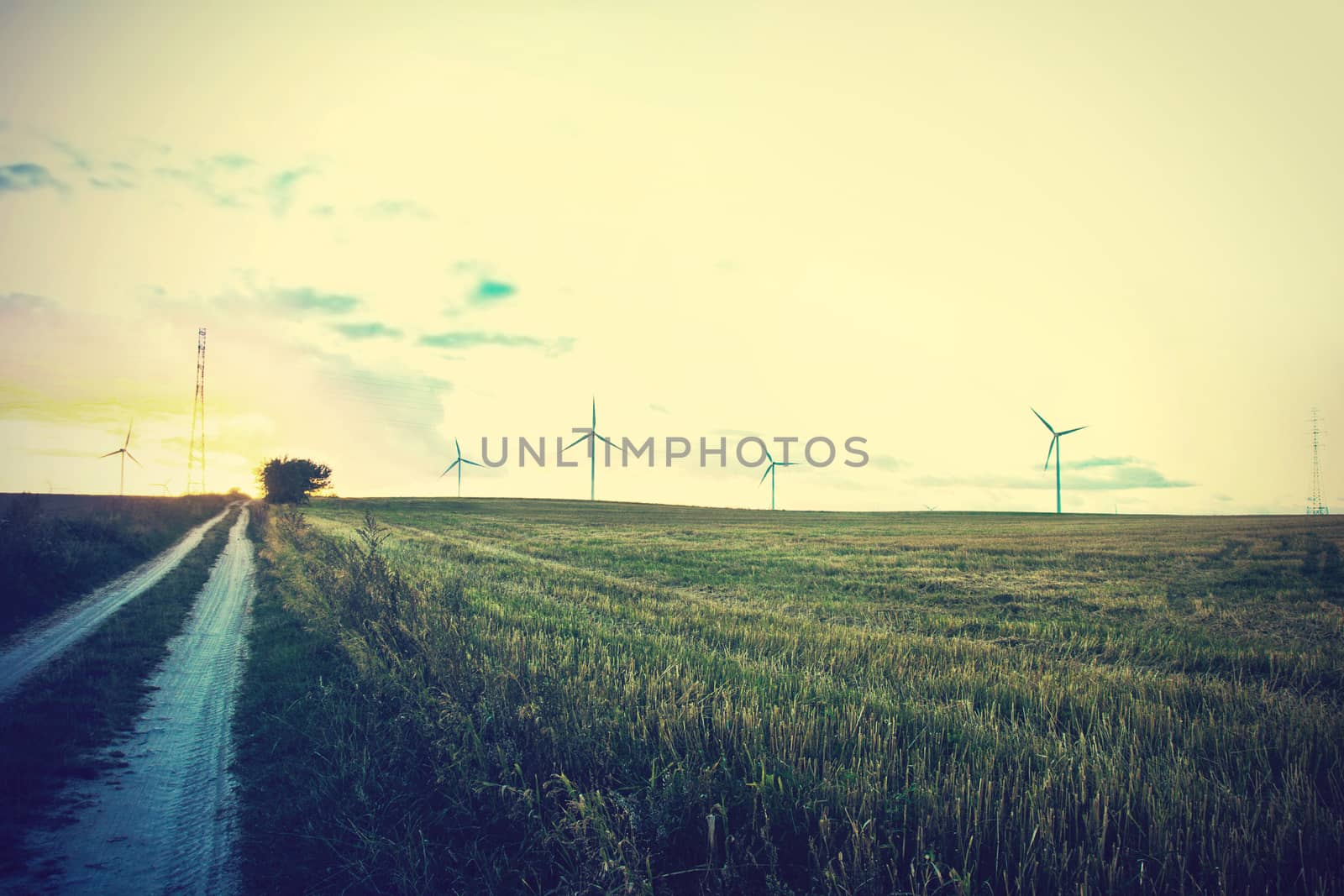 Windmills on the field. Alternative ecological energy. Instagram vintage dark picture.