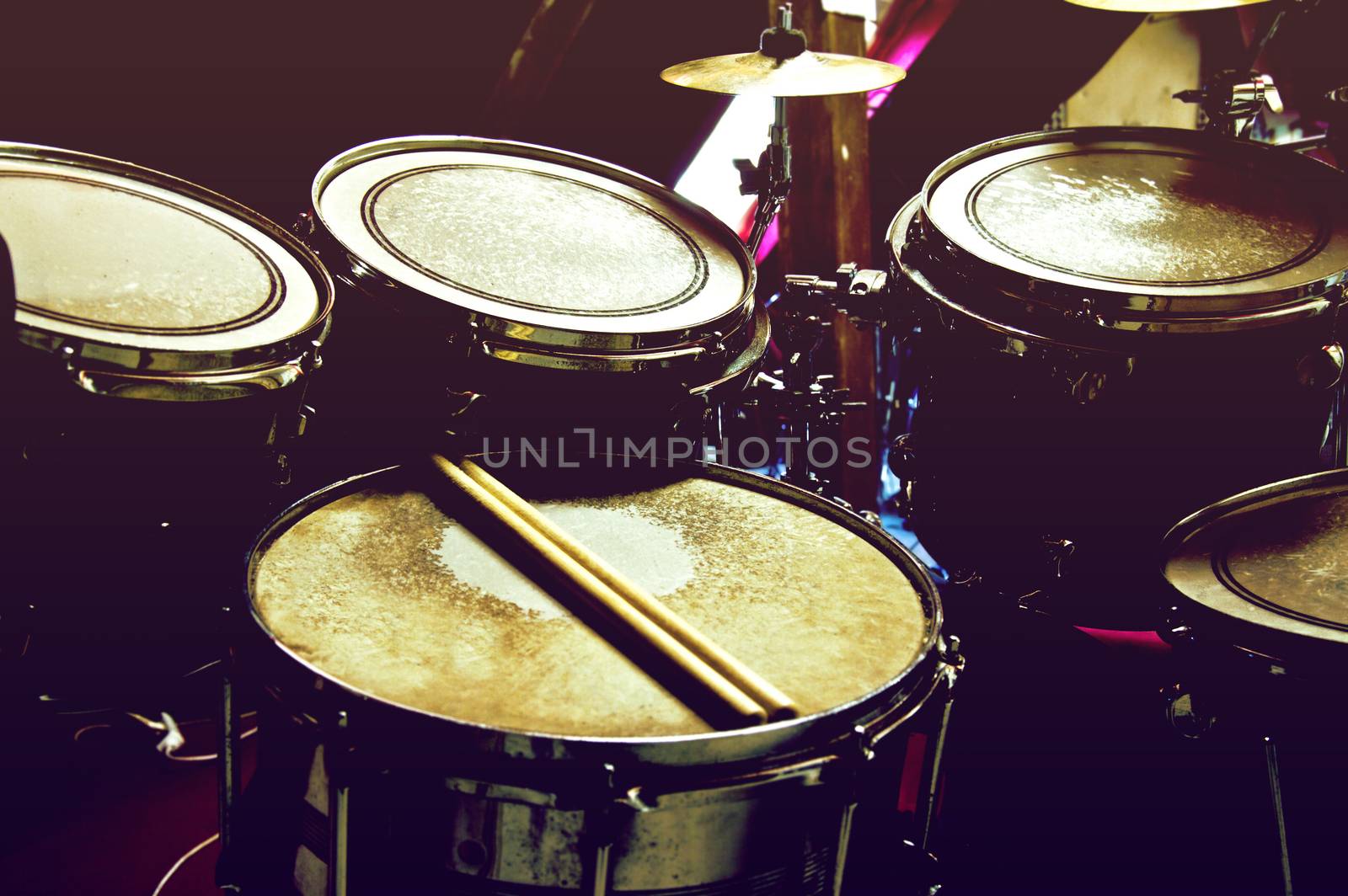 Drums conceptual image. Picture of drums and drumsticks lying on snare drum. Retro vintage instagram picture.