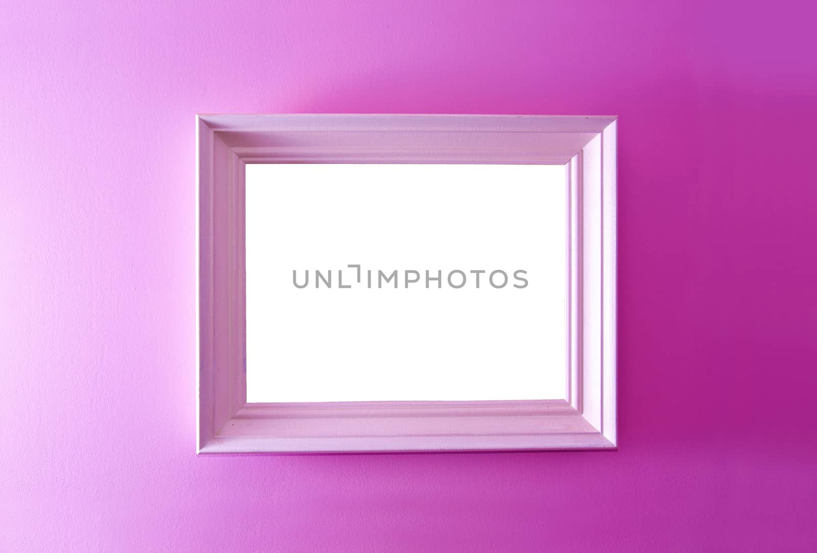 White empty frame on the pink wall. Free copy space.