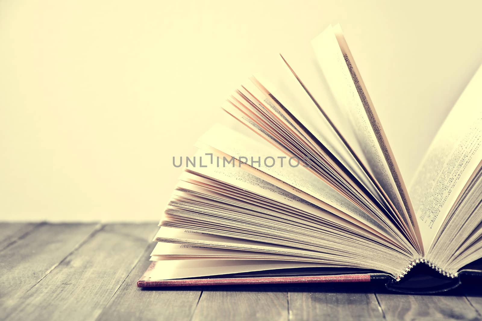Open book lying on the wooden table. Education conceptual image.