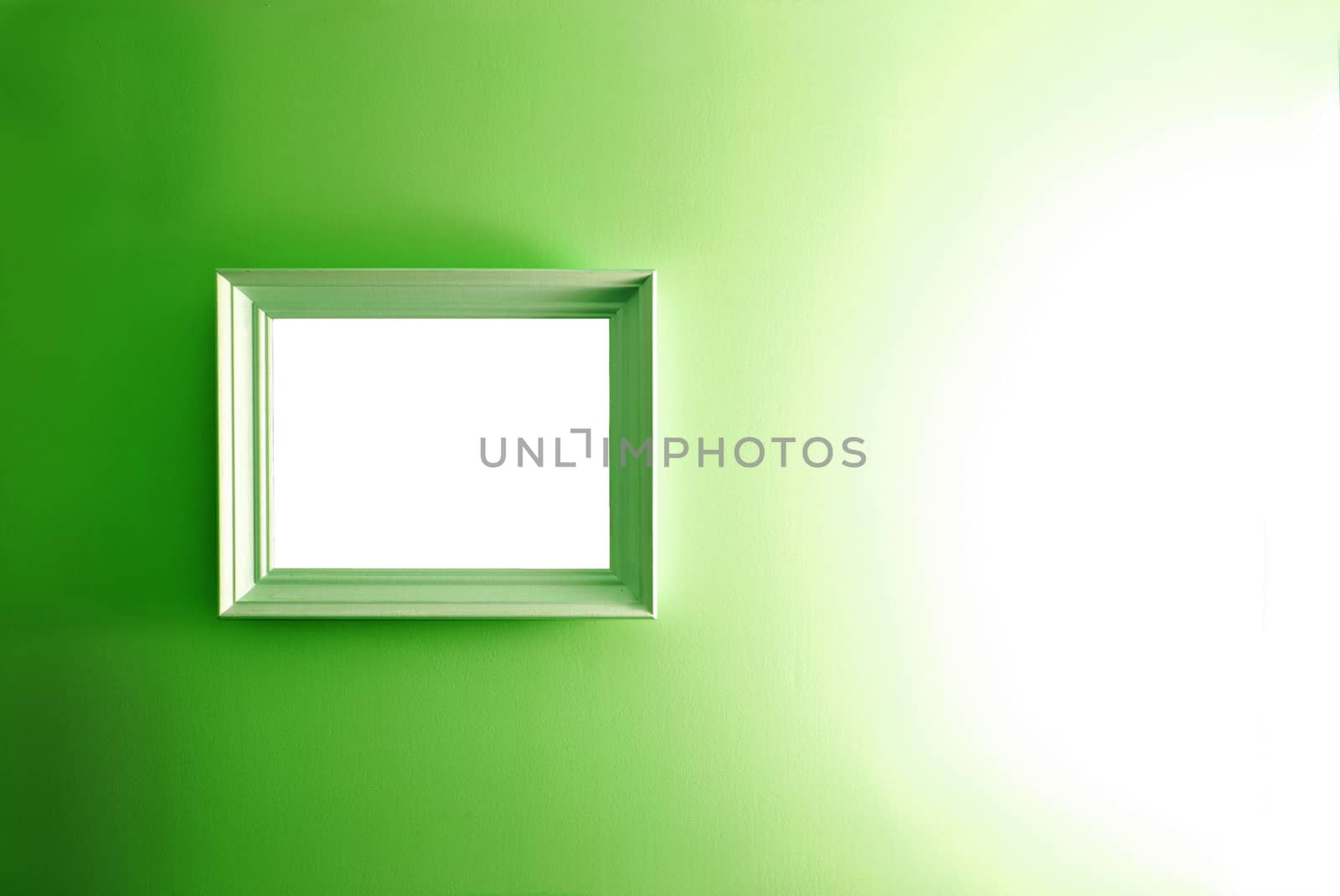 White empty frame on the green wall. Free copy space.