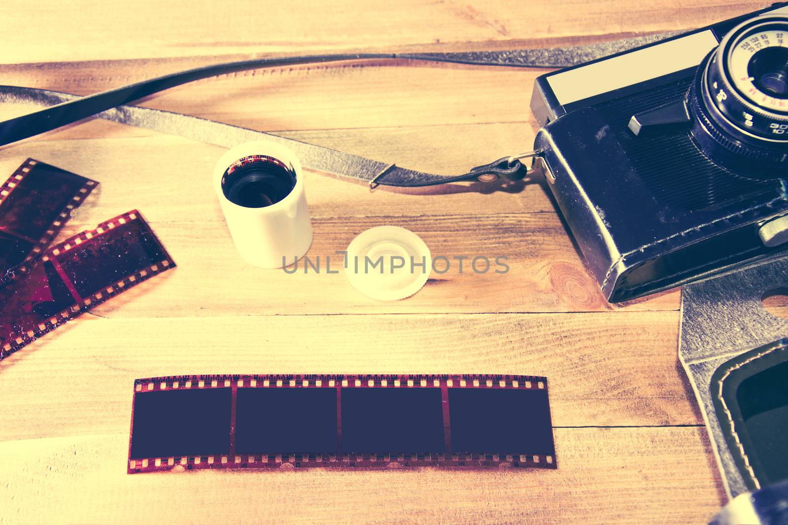 Retro vintage camera and photographic film on wooden background. Instagram retro vintage picture.