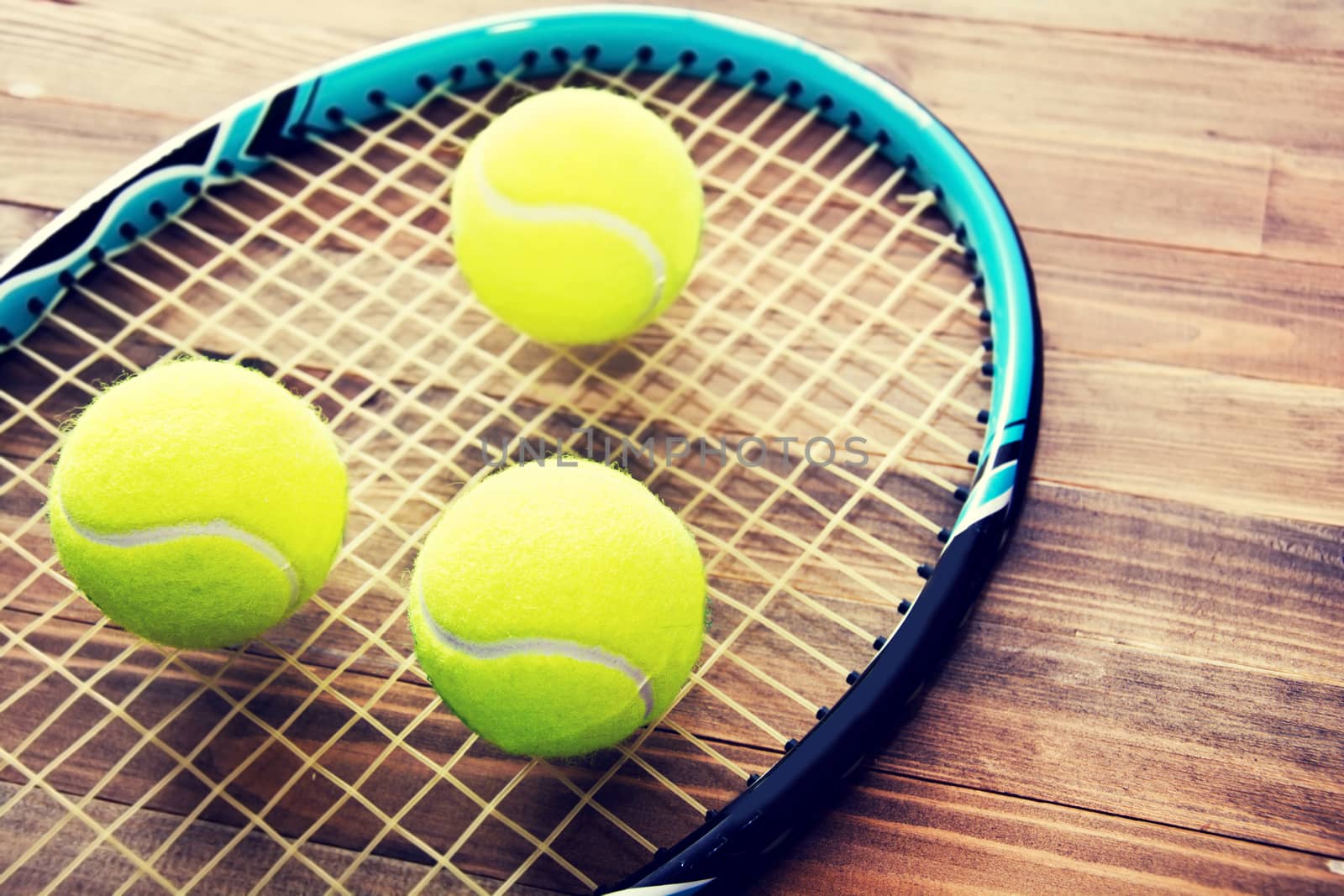 Tennis game. Tennis ball and racket on wooden background. Vintage retro picture.