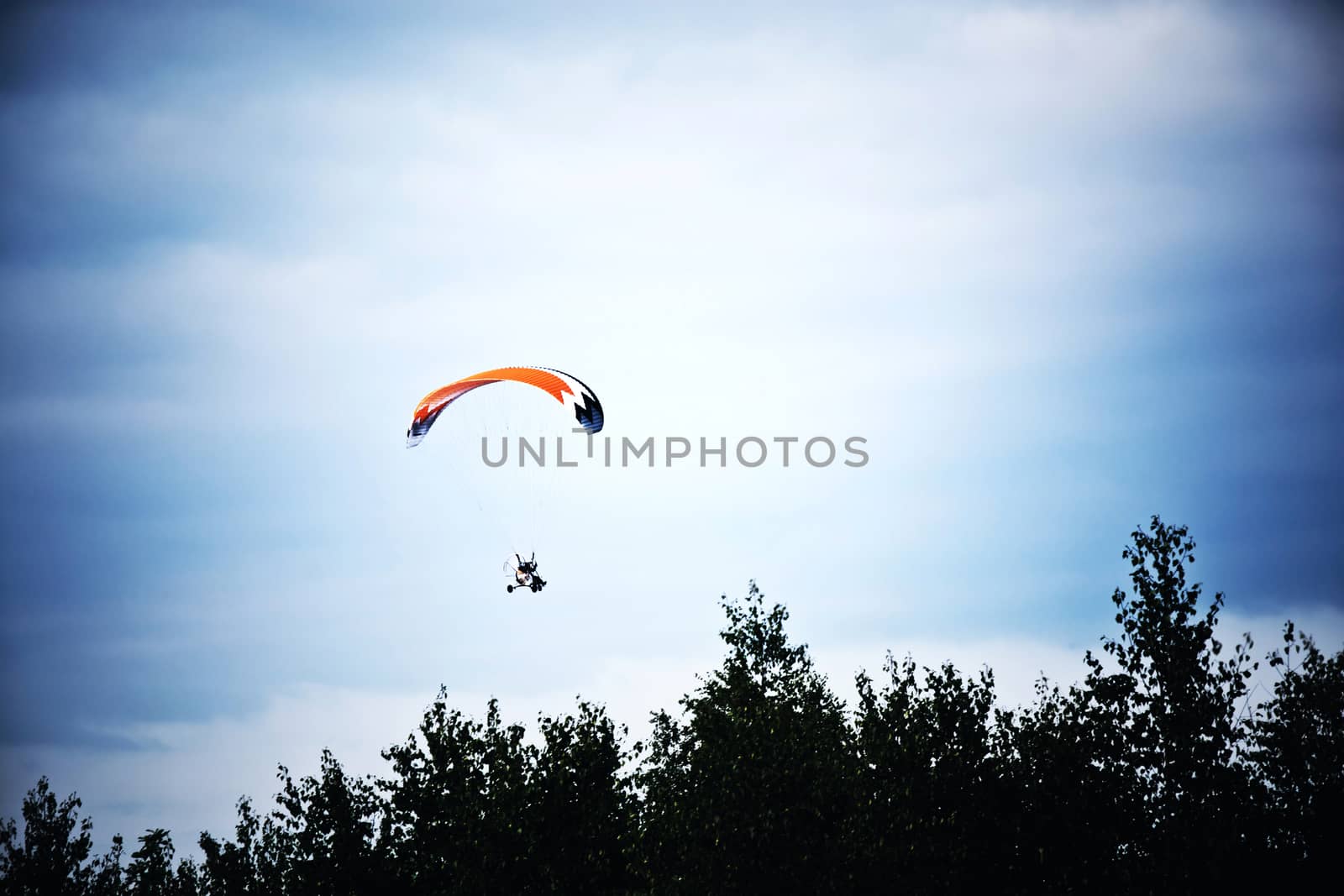 Motorized hang glider on the blue sky. by satariel