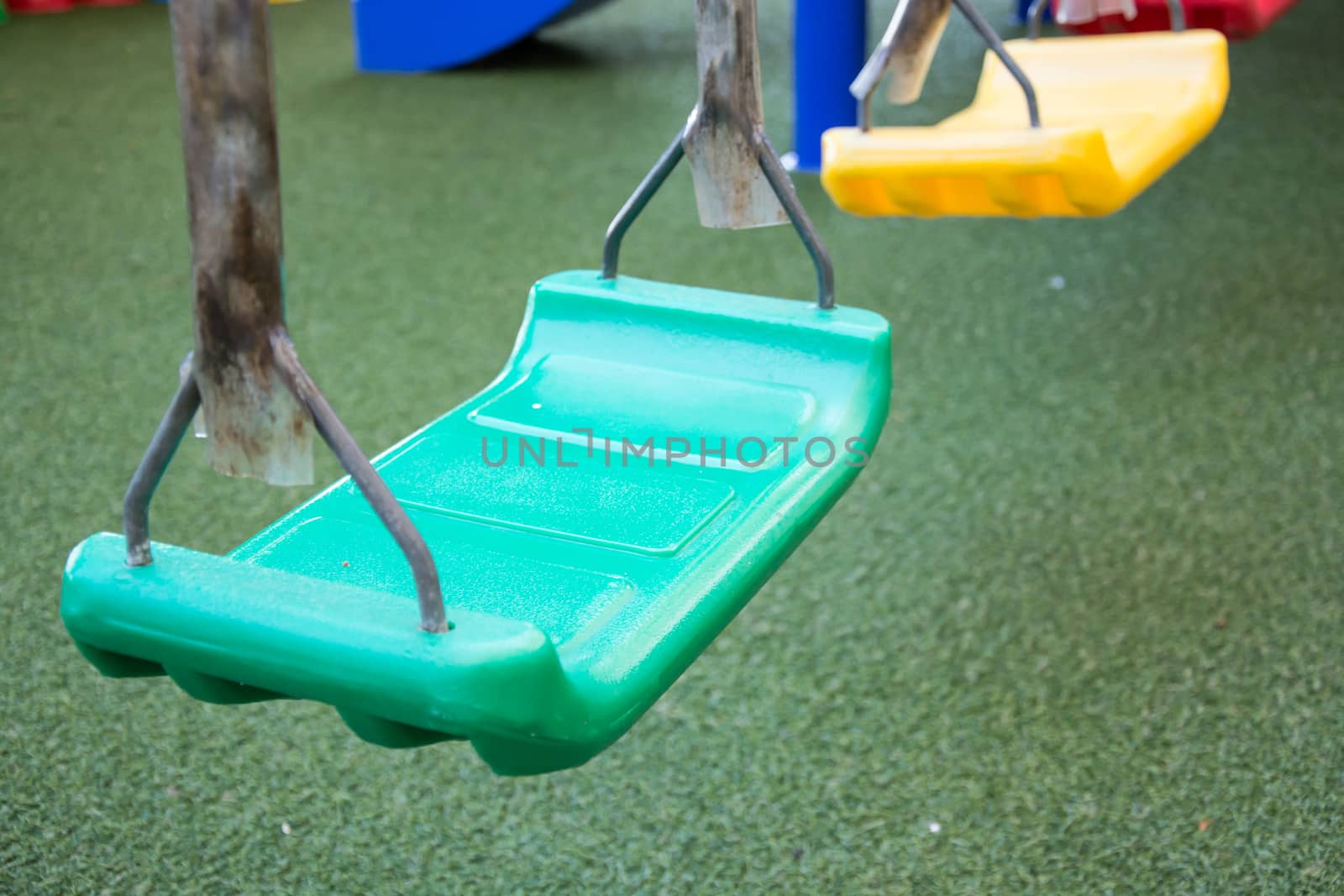Empty chain swings on summer kids playground