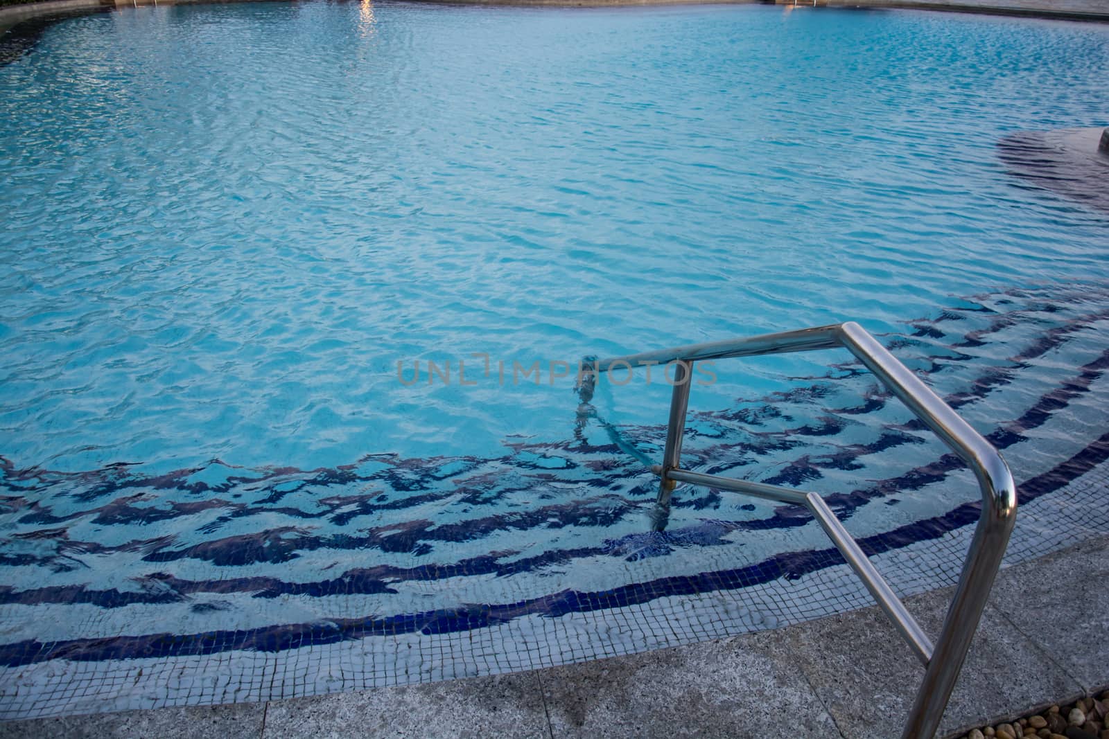 blue swimming pool with teak wood flooring stripes summer vacation