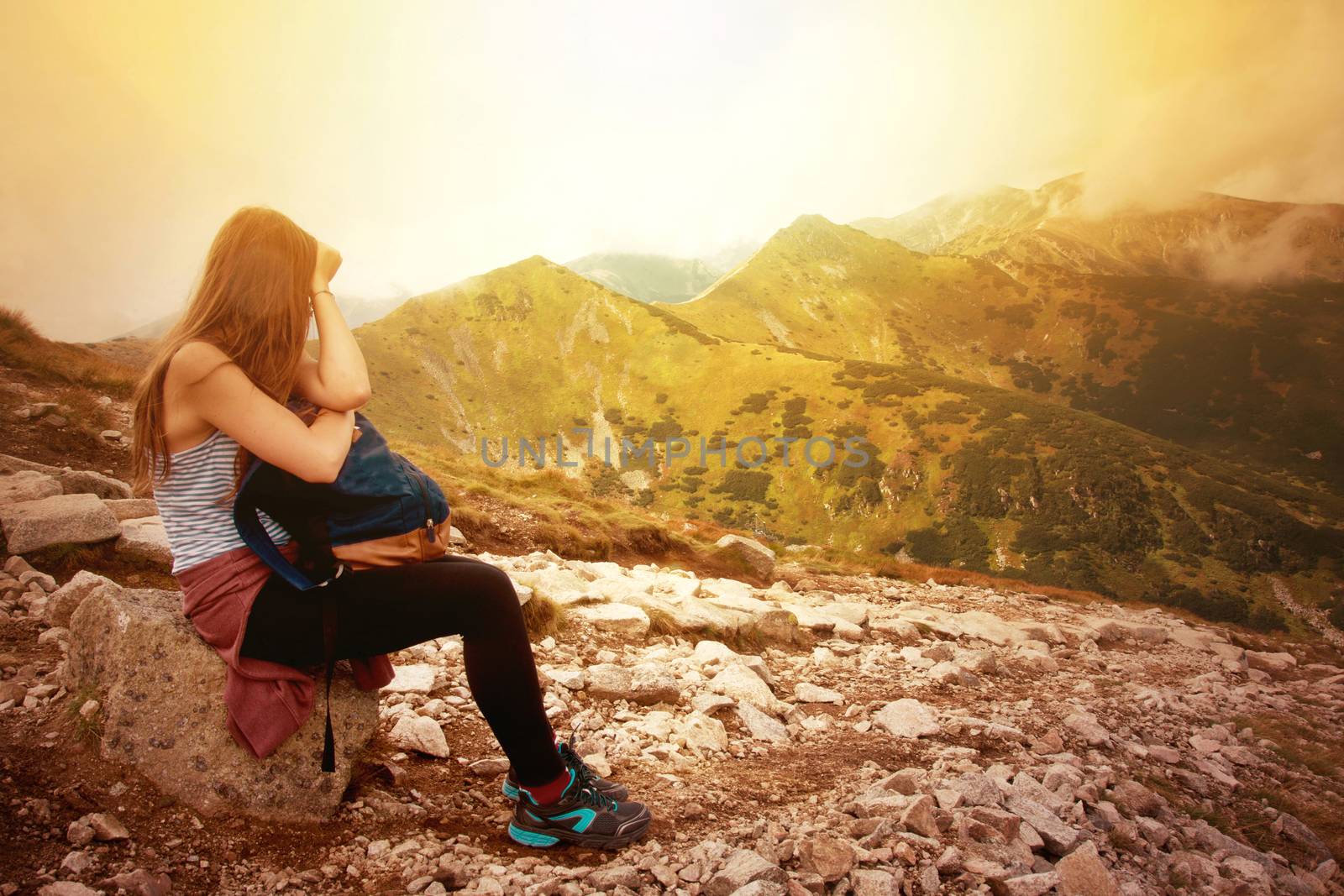 Tourism in mountains. Female tourist rest on the mountain path. Nature in mountains image.