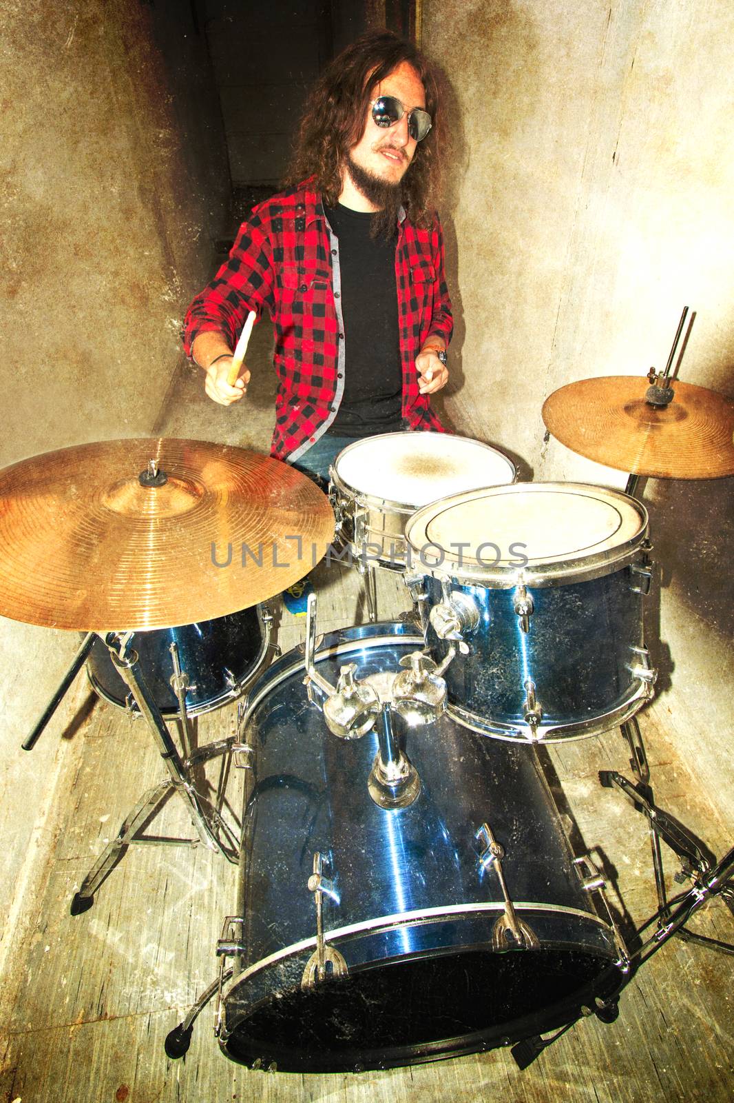 Drums conceptual image. Rock drummer holding drumsticks and playing on drums. Retro vintage grunge picture.