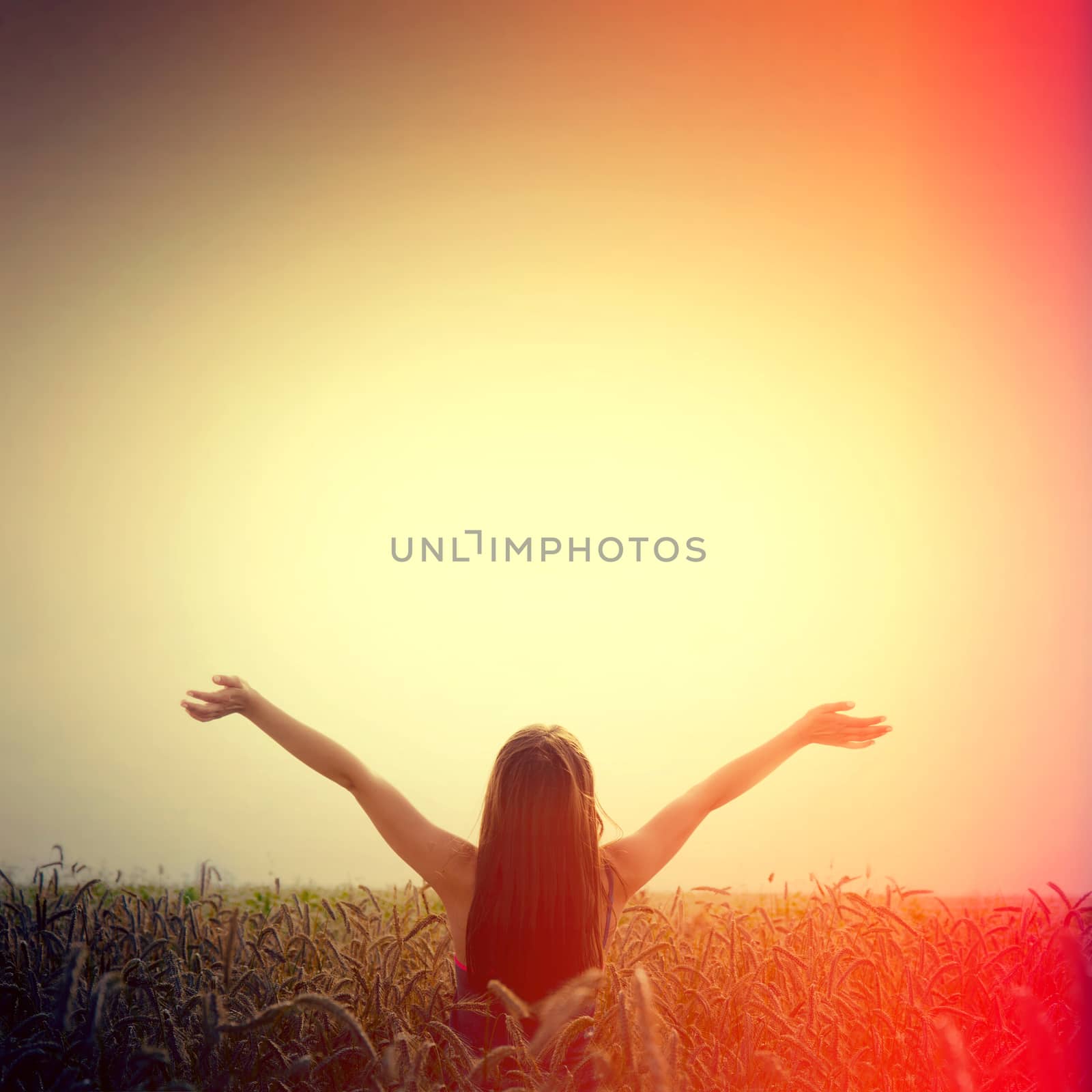 Girl lift her hands to the sky and feel freedom. Happiness and success concept. Instagram sunburst vintage picture.