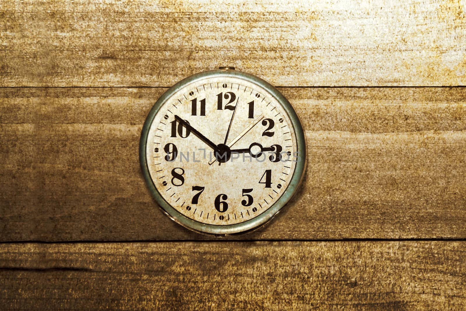 Time, work and business concept. Old clock on wooden background. Grunge picture.