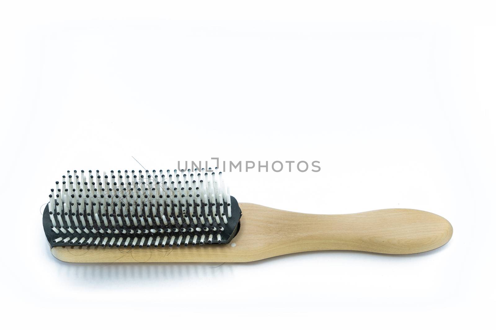 A Wooden handle Comb with hairs loss on white background.