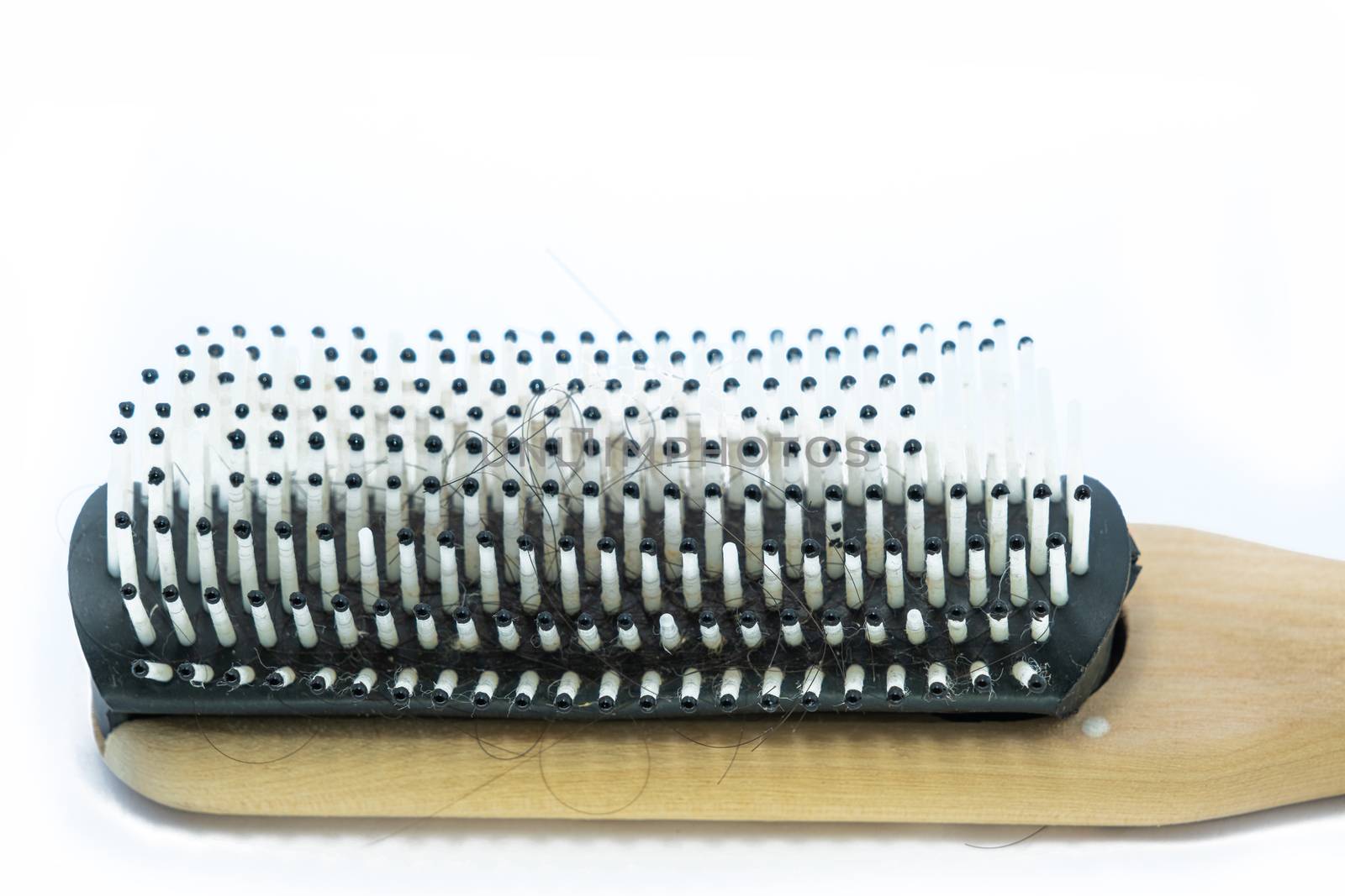 The Close-up Wooden handle Comb with hairs loss on white background.