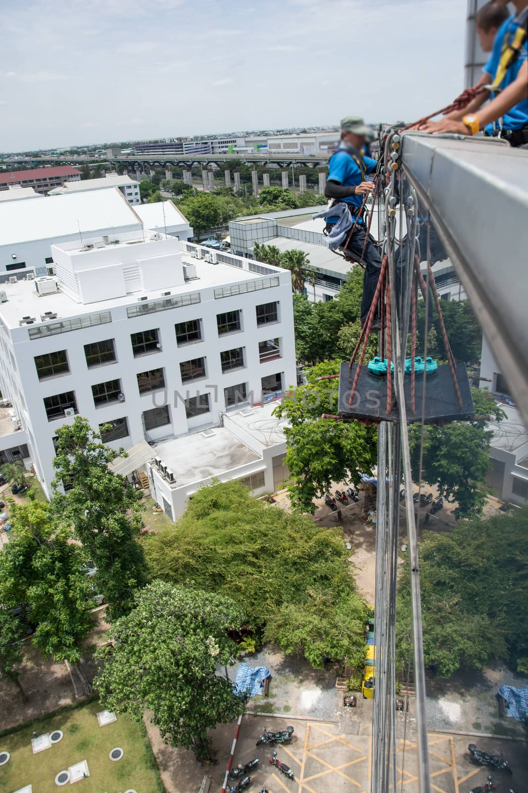 workers cleaning windows service on high rise building