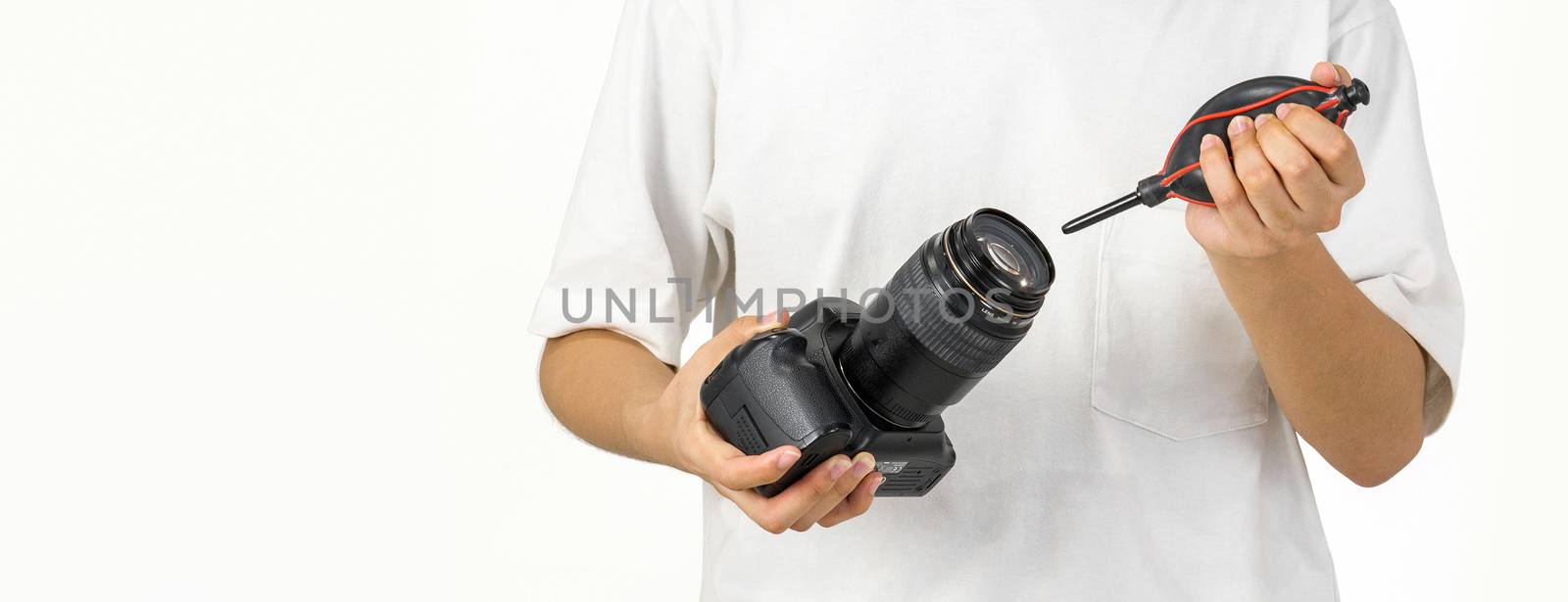 Young photographer is cleaning the camera and lens with a air blower camera cleaning.