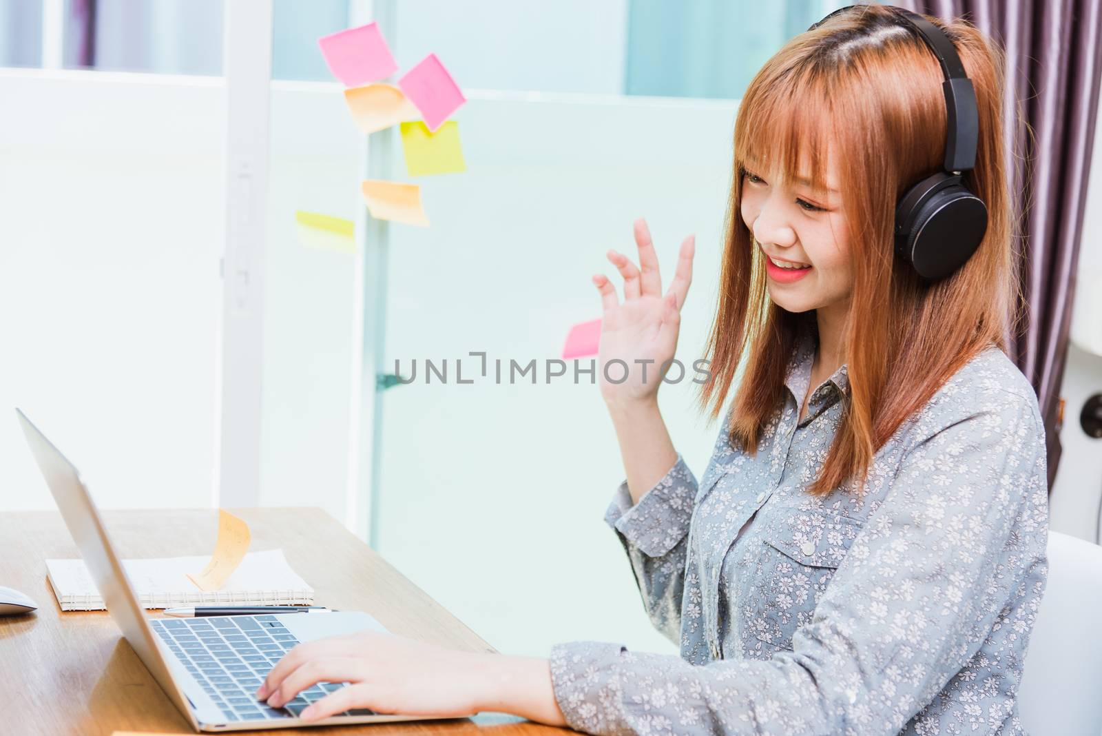 Work from home concept, Happy Asian beautiful young business woman wearing headphone call online conference video call meeting for discussion talking with boos and team together by laptop computer