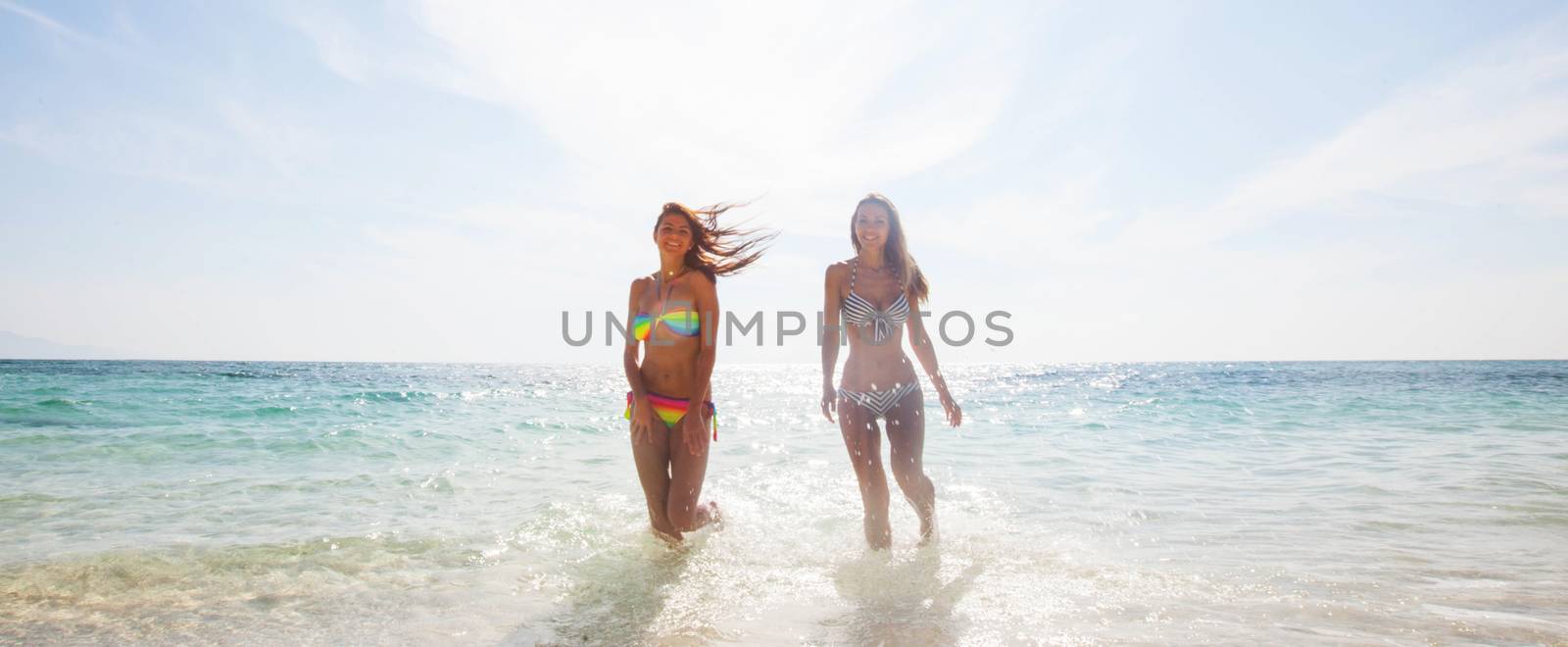 Happy girls running through the water by Yellowj