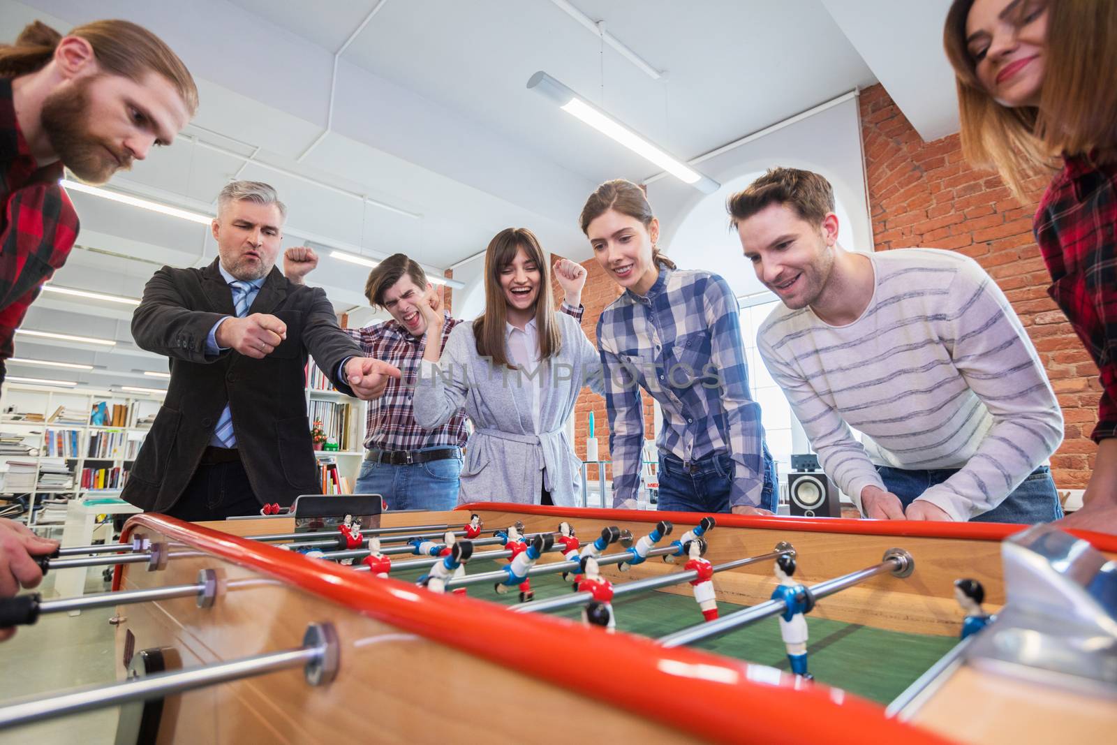 Business people playing table football by Yellowj