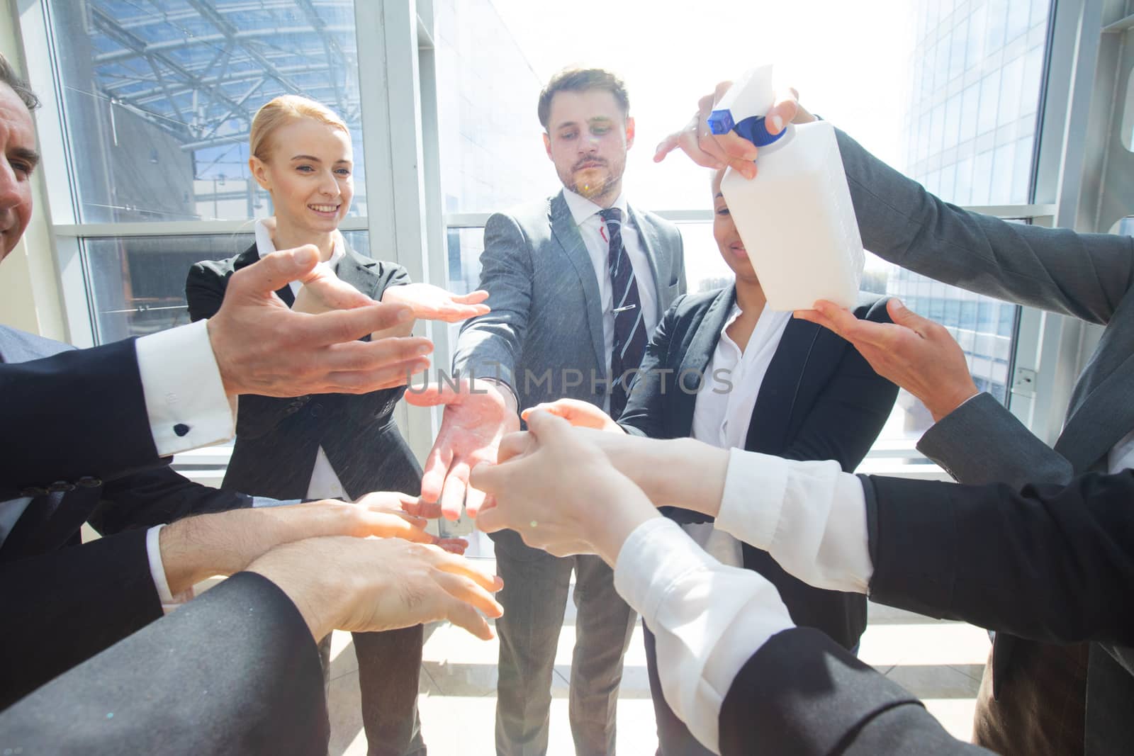 Business people team using hand sanitizer, healthcare and covid-19 prevention concept