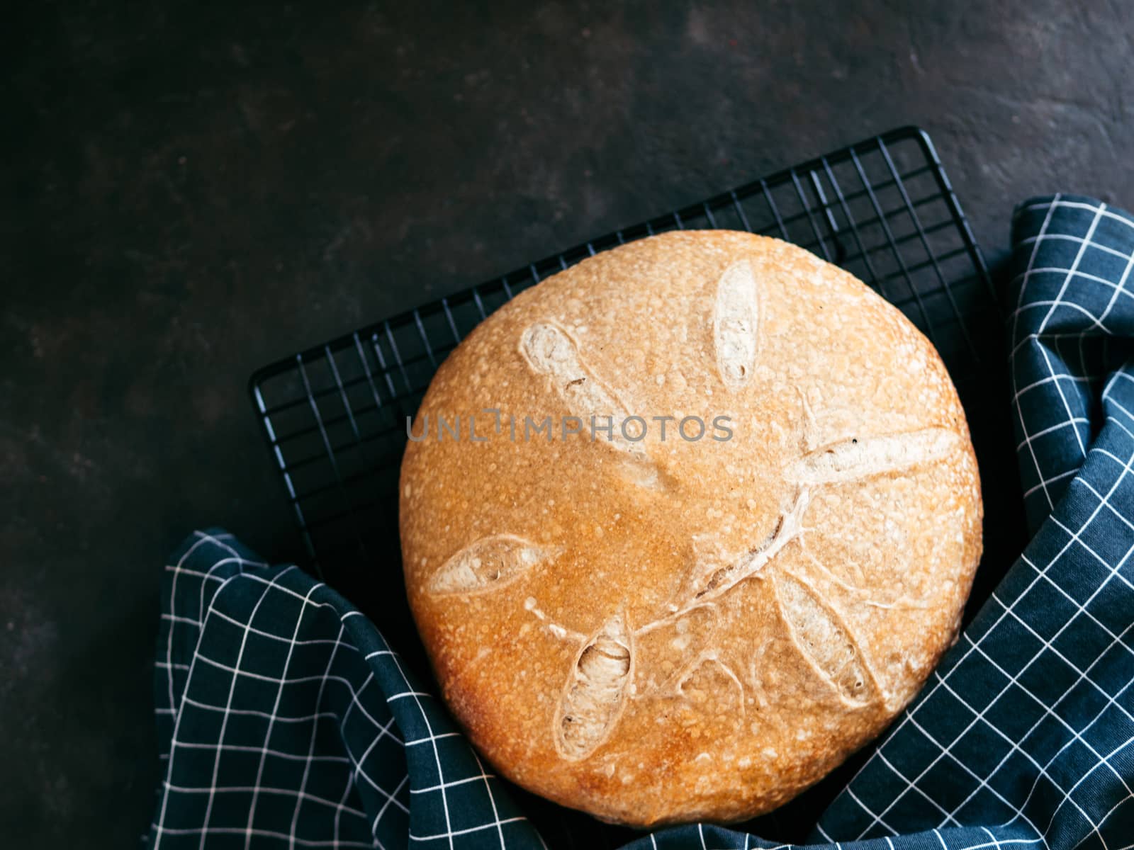Wheat round sourdough bread. Top view of delicious homemade sourdough bread on black background with copy space. Home made sourdough bread making concept.